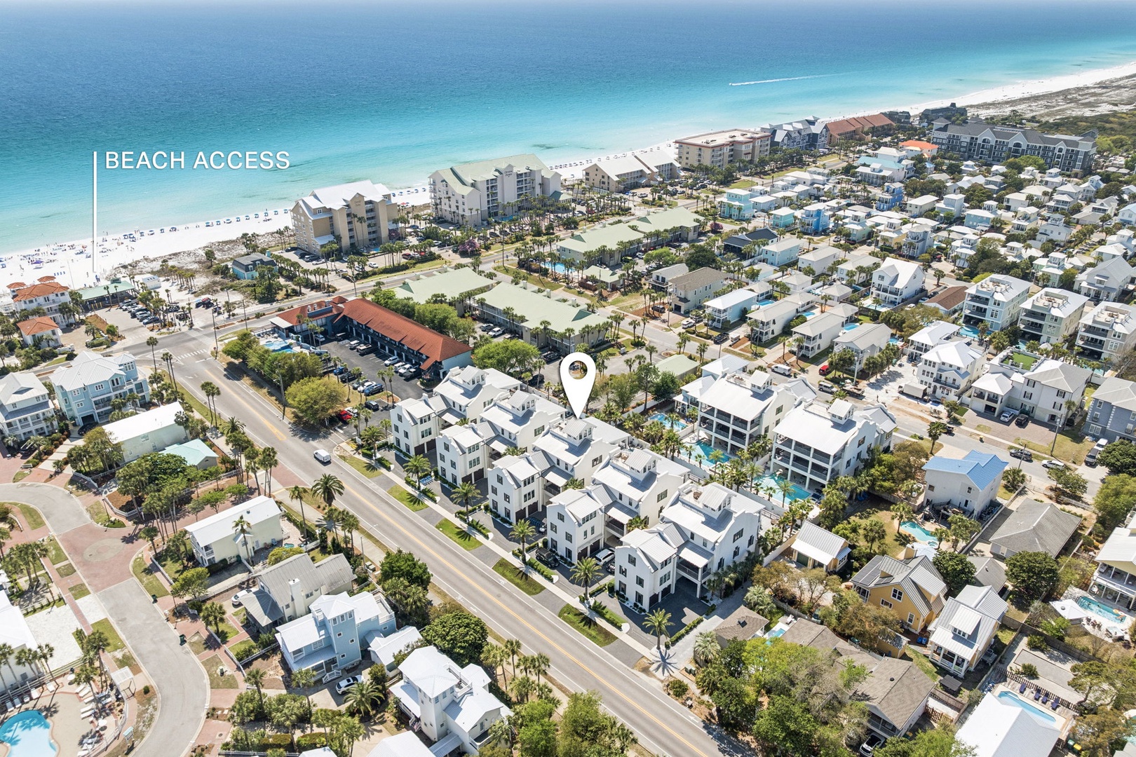 Aerial view of beachfront community with pristine white sand beaches and turquoise waters just steps away from the property.