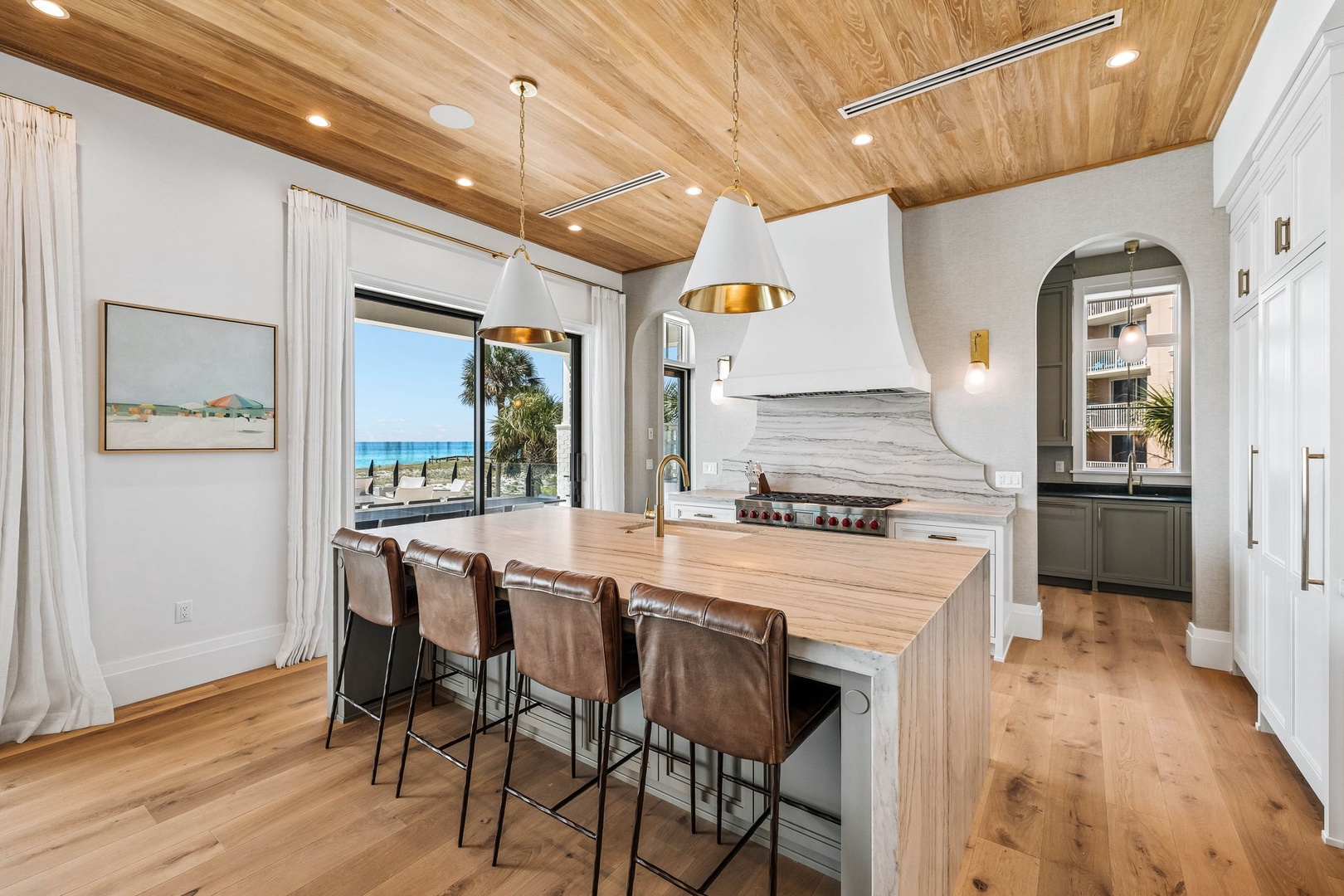 Gather at the island under warm wood ceilings while natural light pours in through expansive windows. Your view of turquoise waters and palms sets the scene for memorable meals together.