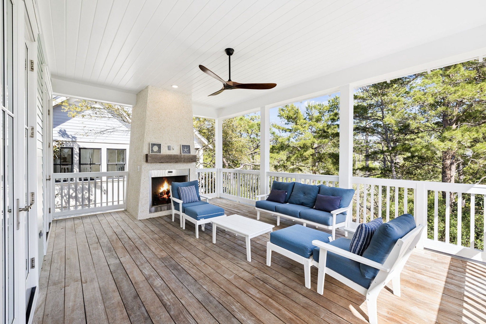 Unwind on your private covered deck with plush seating, crackling fireplace, and peaceful tree views for the perfect outdoor retreat.