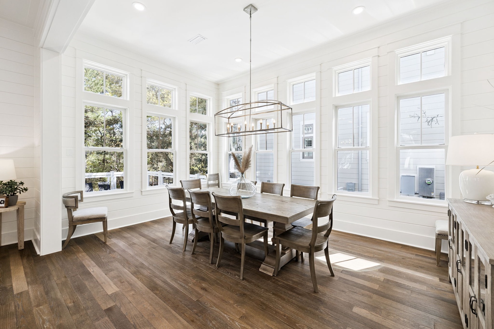 Gather around this elegant dining table where natural light streams through expansive windows, creating the perfect atmosphere for memorable meals with your loved ones.