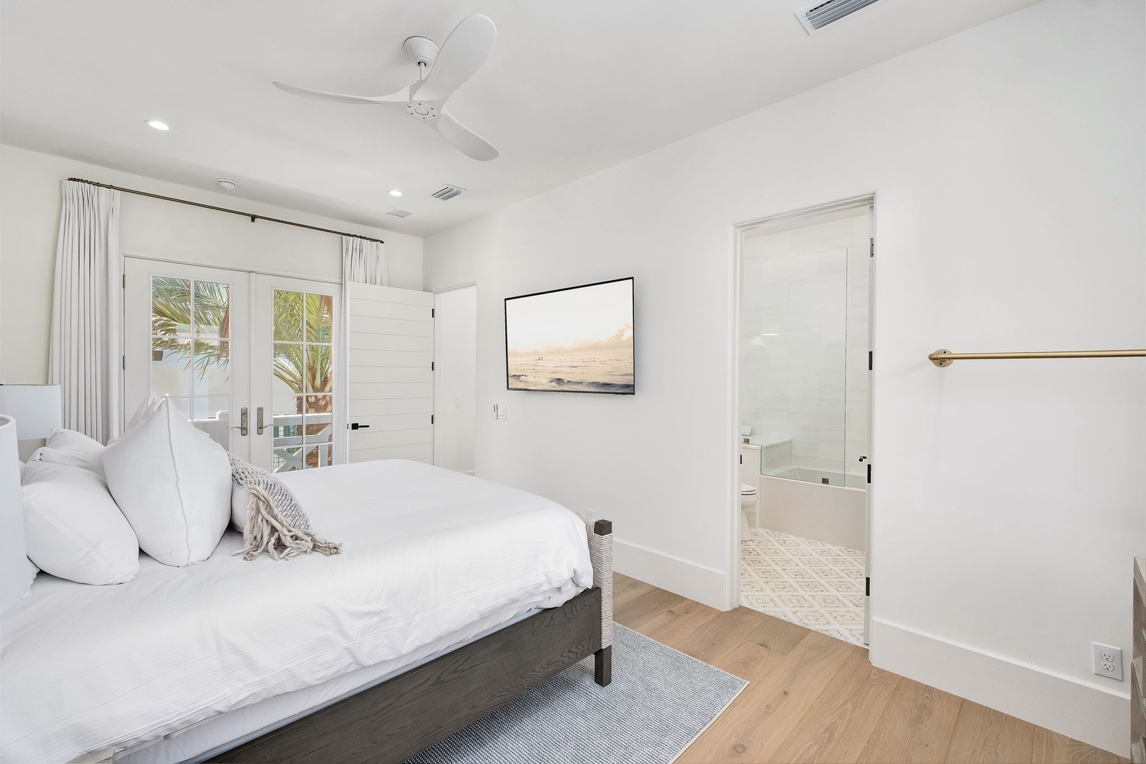 Drift off in this serene bedroom with crisp linens, a soothing coastal palette, and direct access to your private ensuite and outdoor terrace.