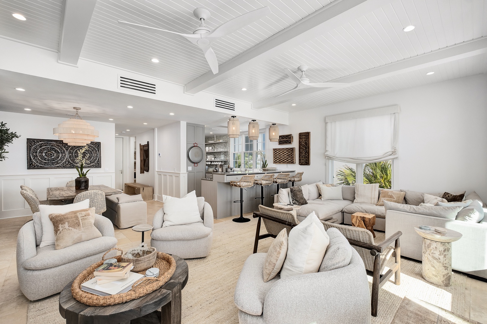 Sink into plush seating in your open-concept living space, where soaring ceilings and coastal charm create the perfect backdrop for relaxation.