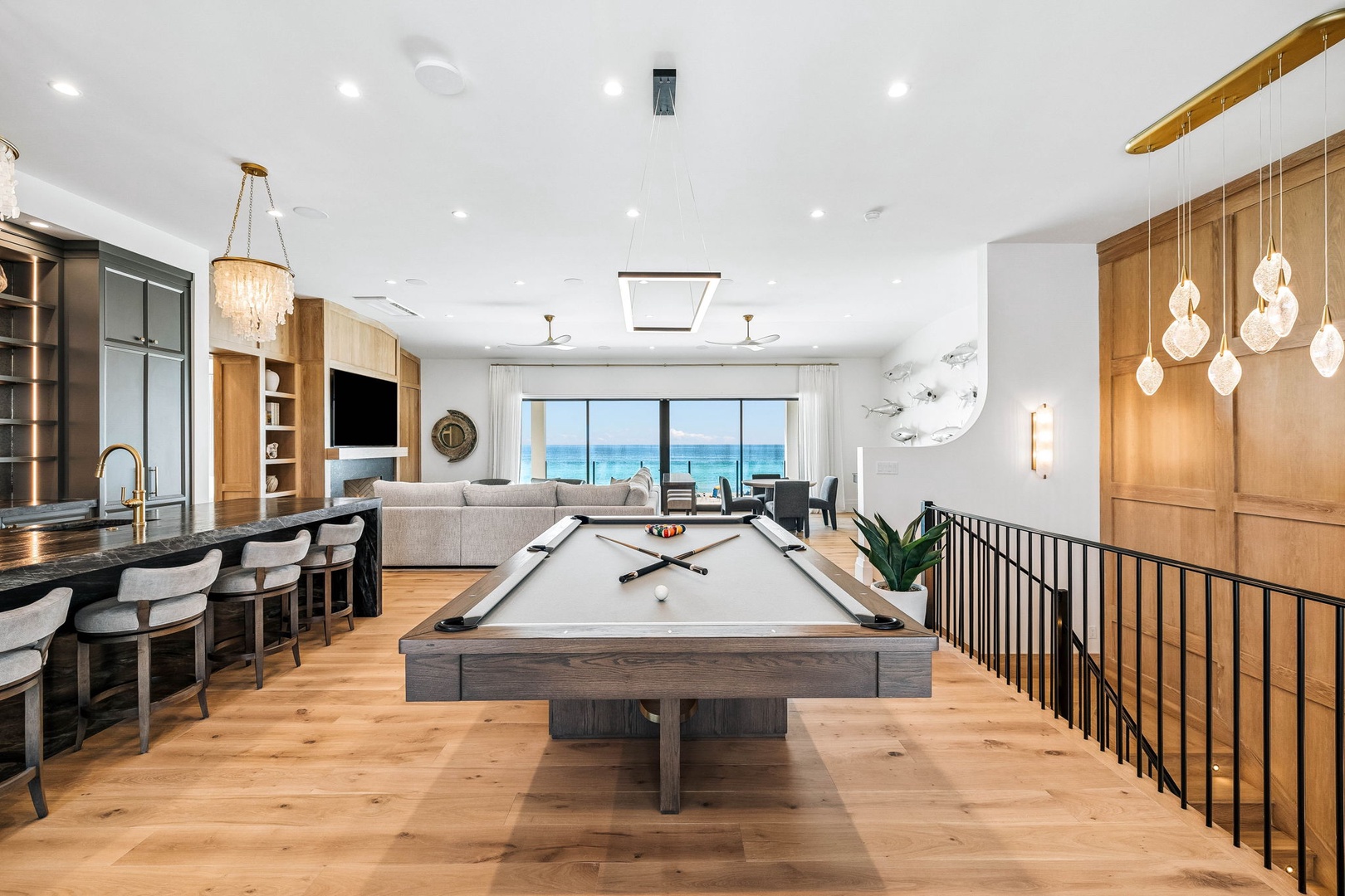 Unwind with a game of pool before drifting to the lounge area, where stunning ocean views through expansive windows invite relaxation and create unforgettable moments during your stay.
