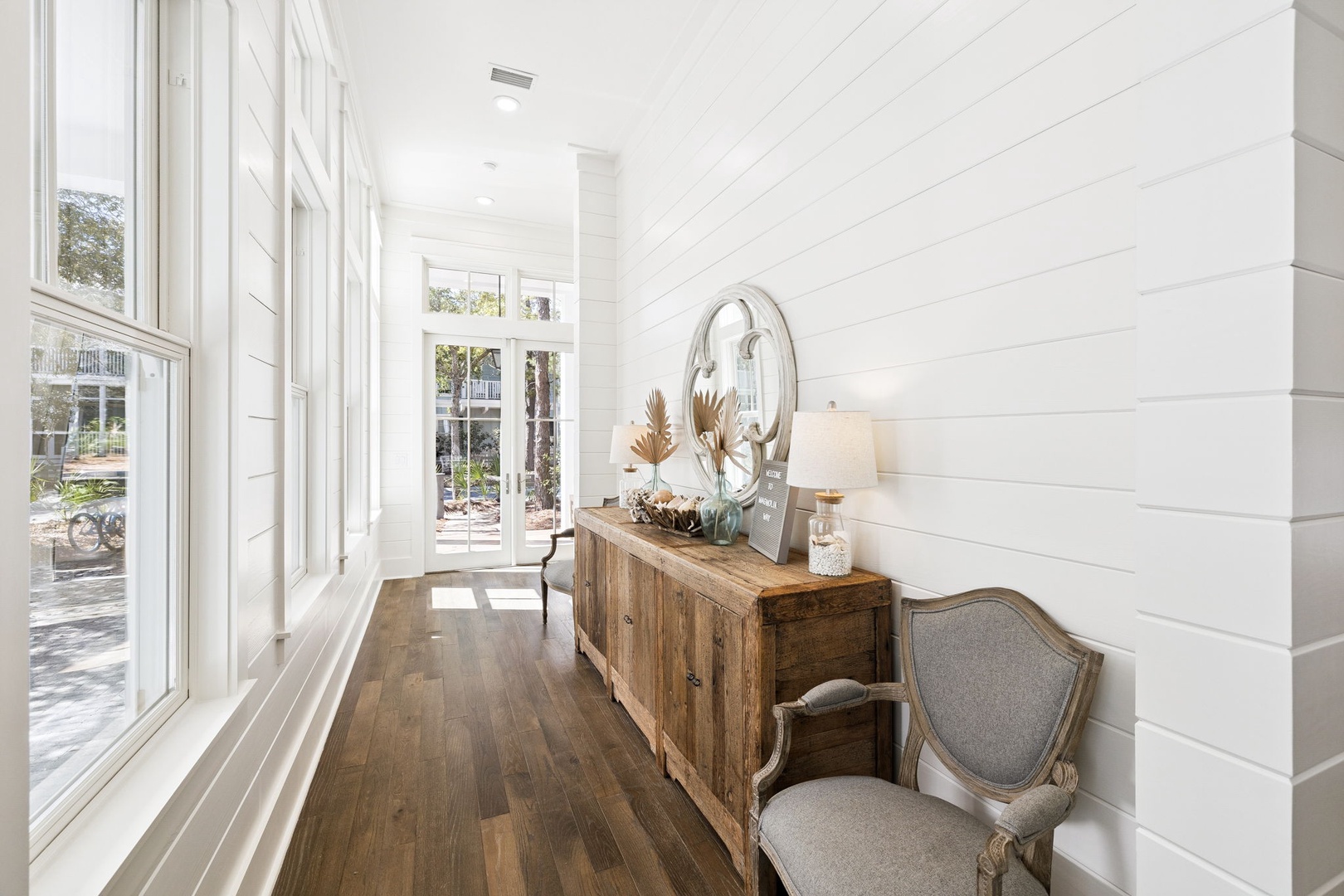 Bright hallway with elegant furniture and rich hardwood floors creates a welcoming entrance to your peaceful retreat.