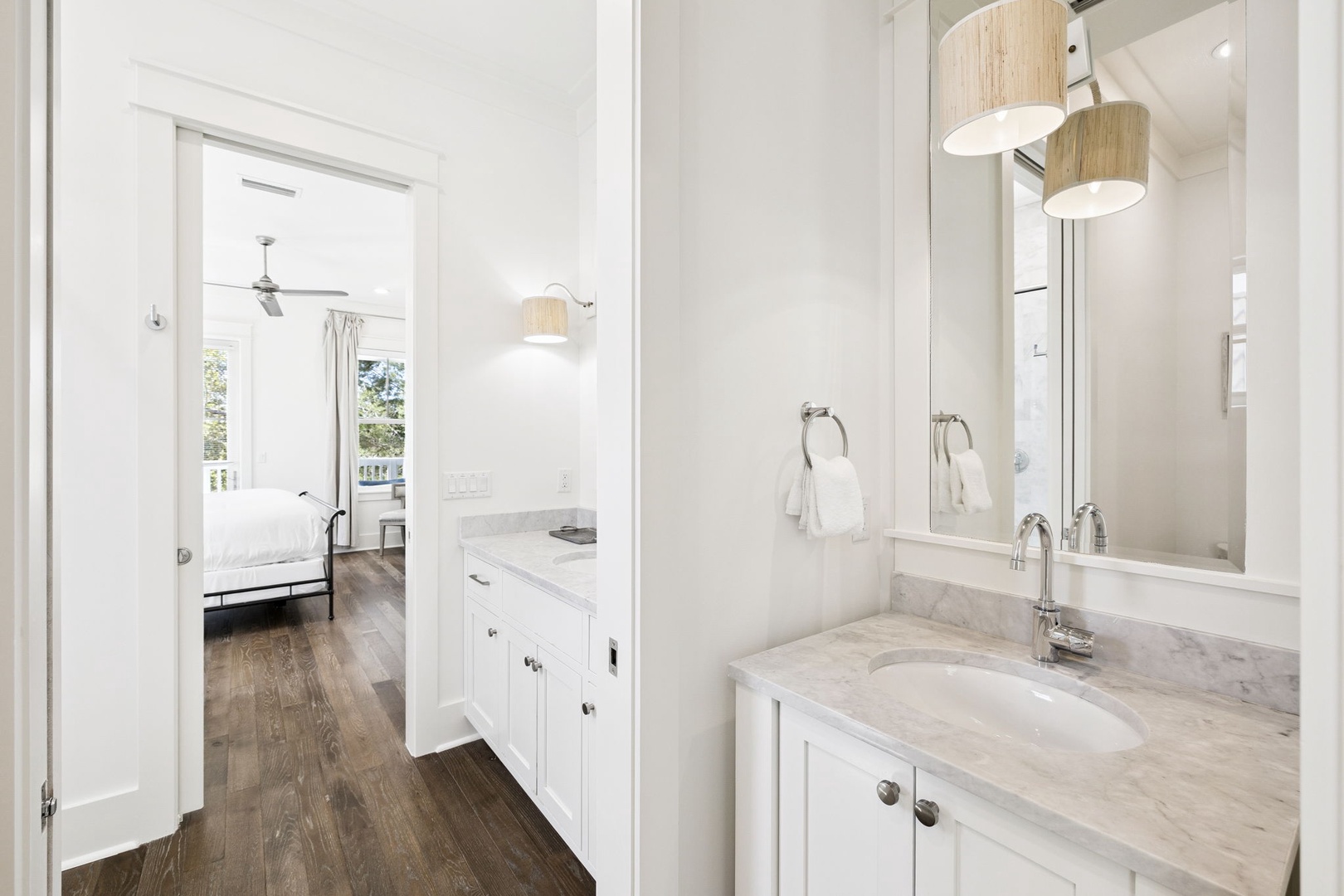 Unwind in your pristine marble-topped vanity with modern fixtures, seamlessly connecting to your peaceful bedroom retreat.