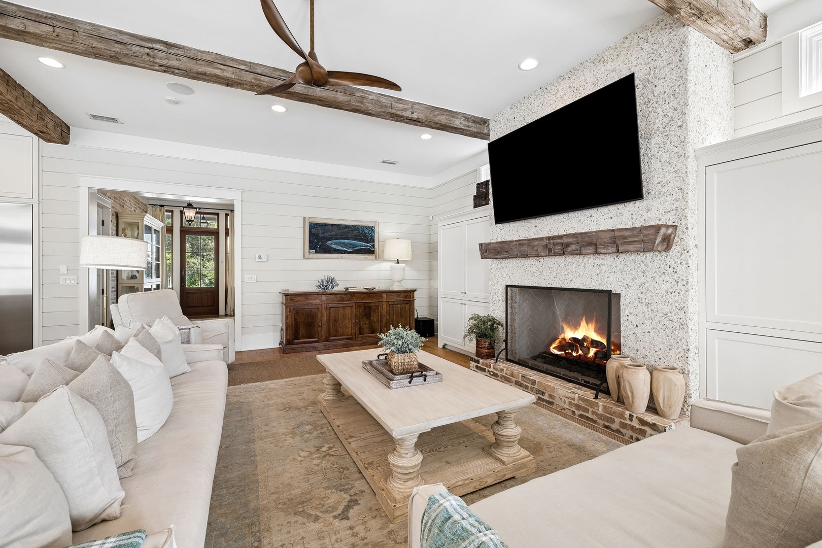 Sink into plush seating and let the warmth of the glowing fireplace embrace you. Rustic beams overhead and soft textures create a soothing retreat where relaxation comes effortlessly.