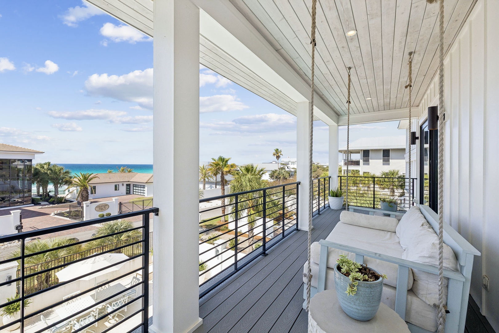 Unwind on your private covered balcony with stunning ocean views, featuring a cozy swing bed perfect for morning coffee or evening relaxation.