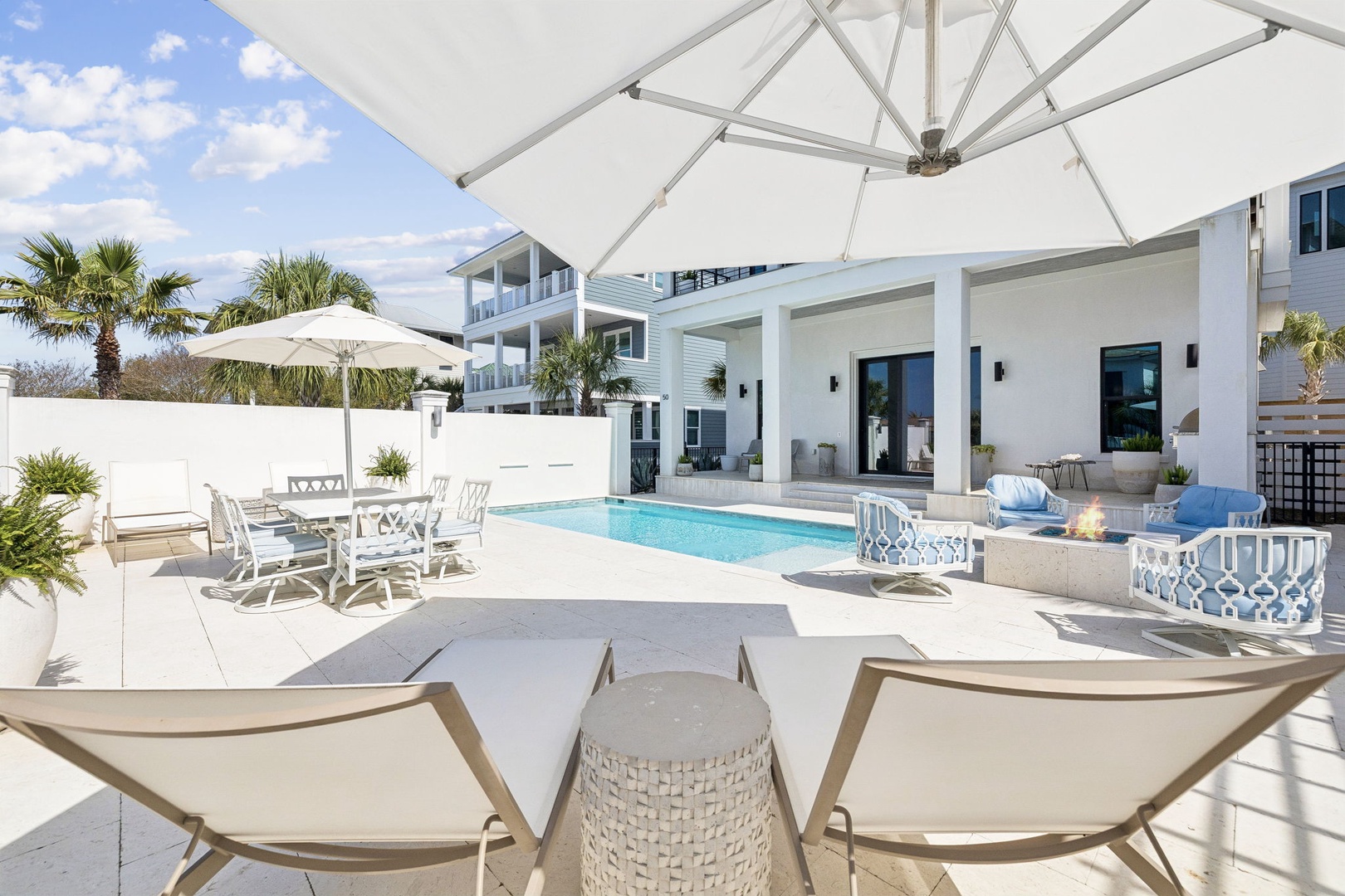 Dive into your private paradise with a sparkling pool, comfortable loungers, and shaded dining under tropical palms.