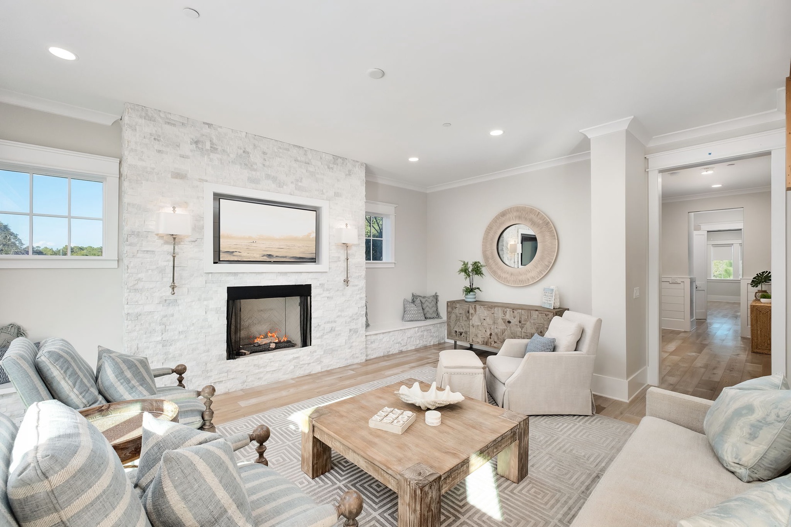 Sink into plush seating by your cozy fireplace, where natural light and elegant furnishings create the perfect spot for relaxation.