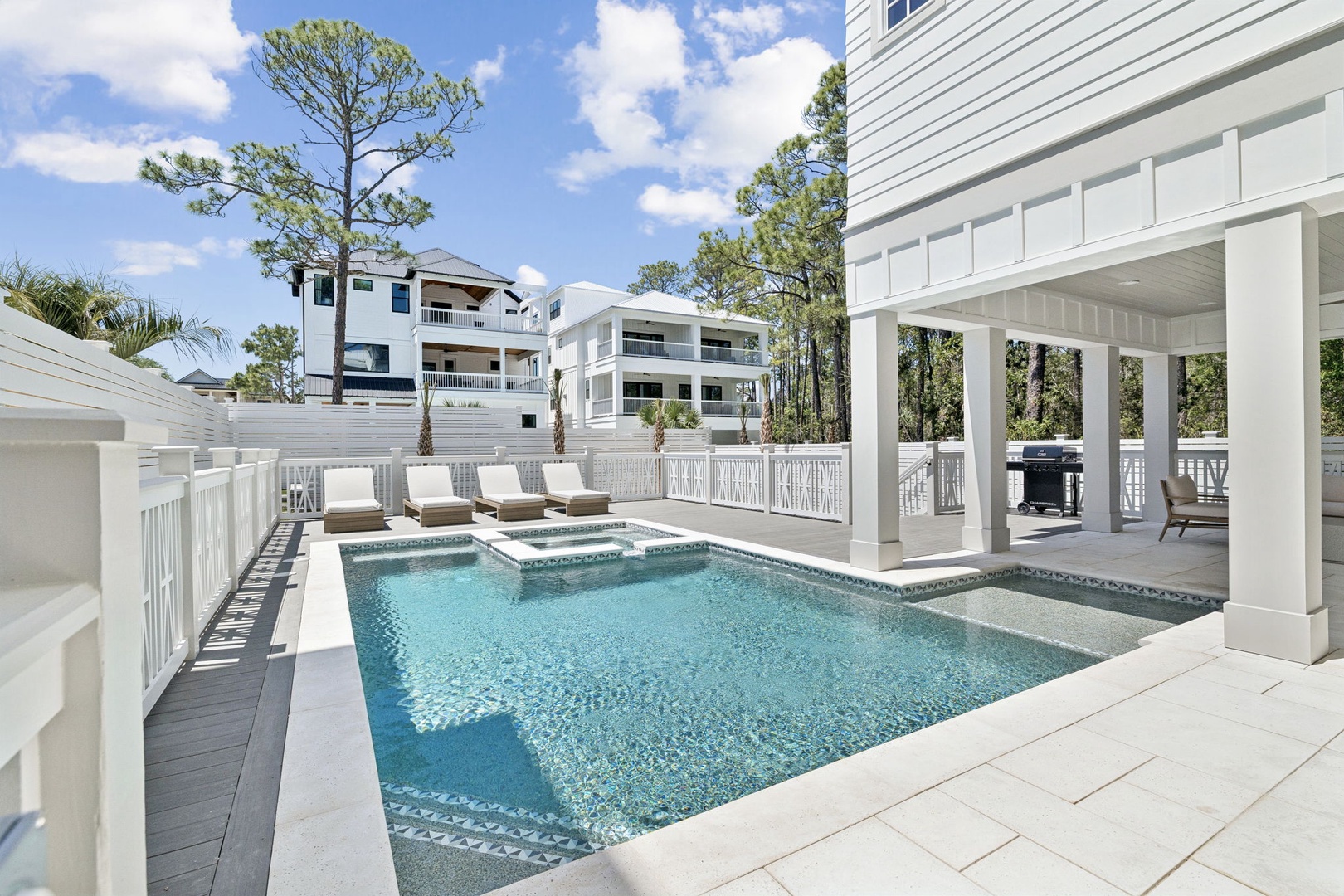 Dive into your private oasis with a sparkling pool, hot tub, and covered lounge space surrounded by tropical palms.