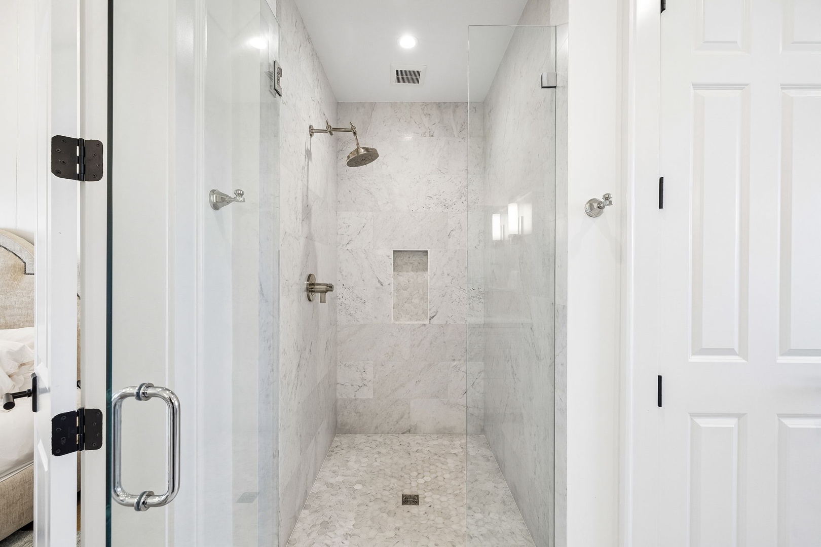 Immerse yourself in this elegant walk-in shower, where soft marble walls and rainfall showerhead create your private spa retreat. Modern glass enclosure and recessed lighting add refined comfort.