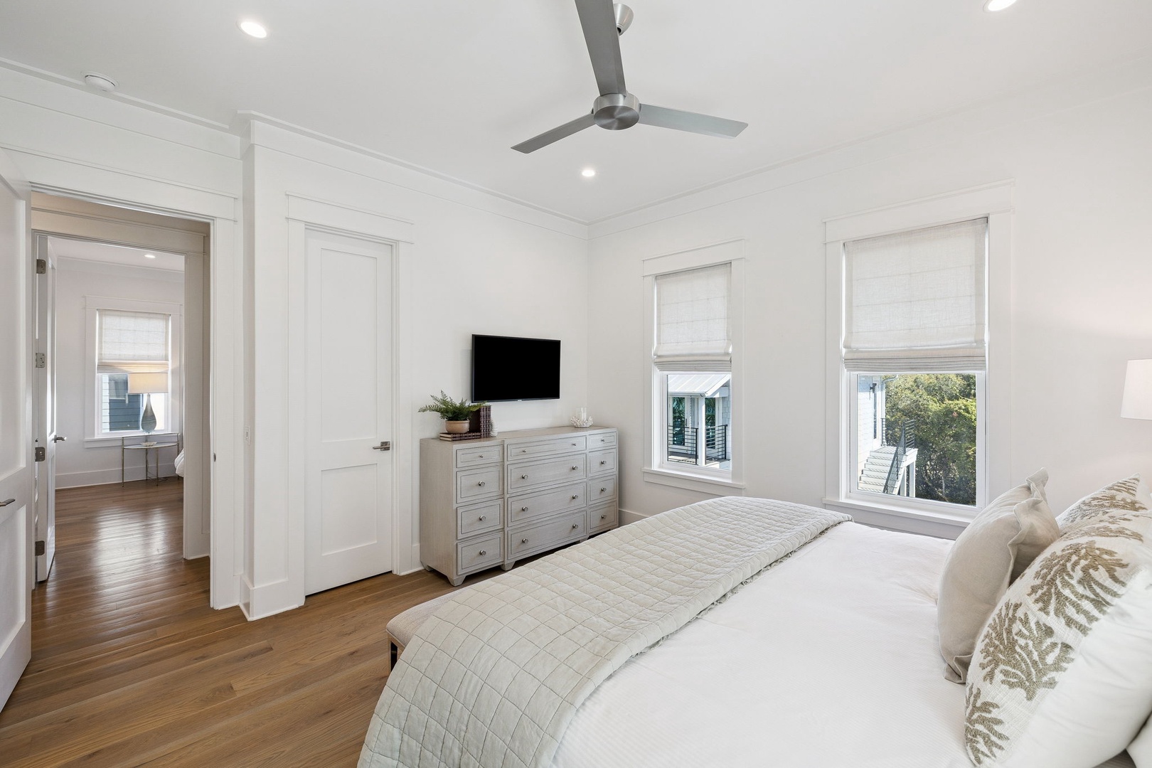 Drift off in your serene bedroom sanctuary featuring crisp linens, a gentle ceiling fan, and natural light streaming through your windows.