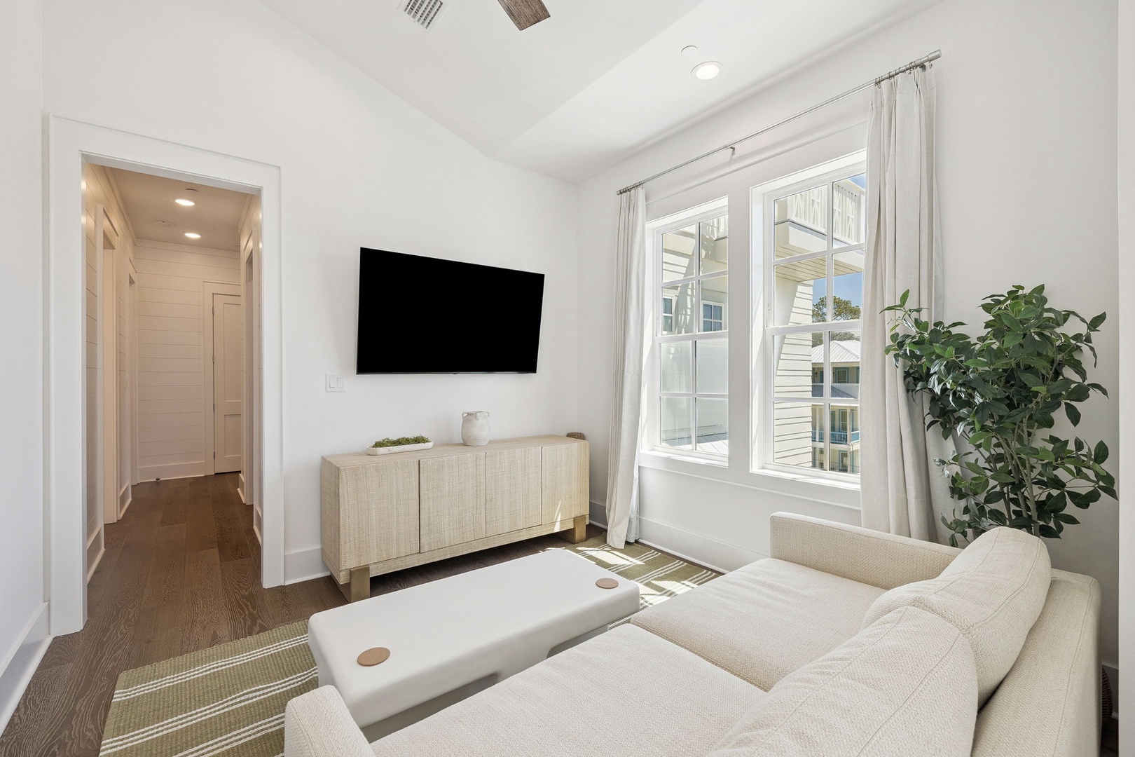 Unwind in your bright living space with plush seating, smart TV, and natural light streaming through large windows.