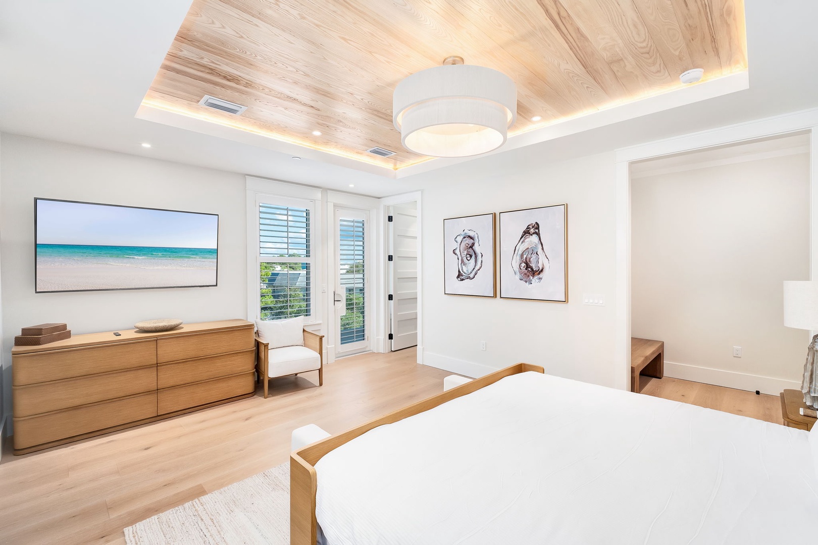 Unwind in your serene bedroom with soft coastal tones, warm wood accents, and calming natural light filtering through plantation shutters.