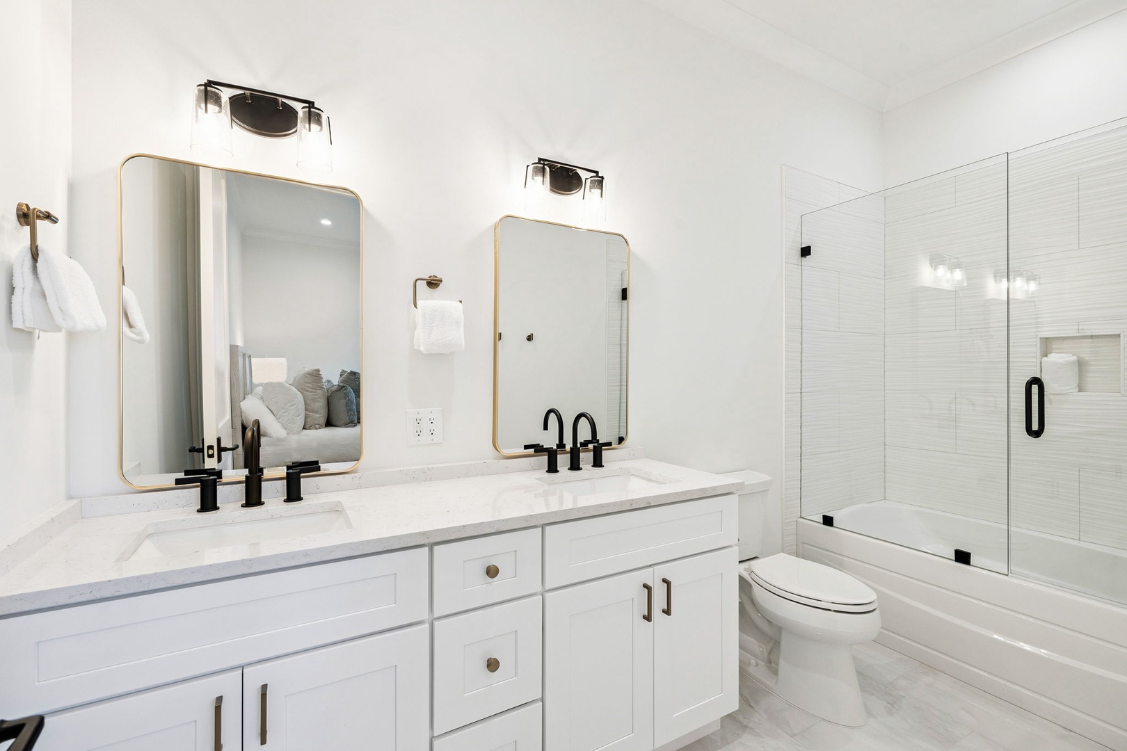 Step into your spa-like bathroom featuring dual vanities, marble countertops, and a spacious tub-shower combo for ultimate relaxation.