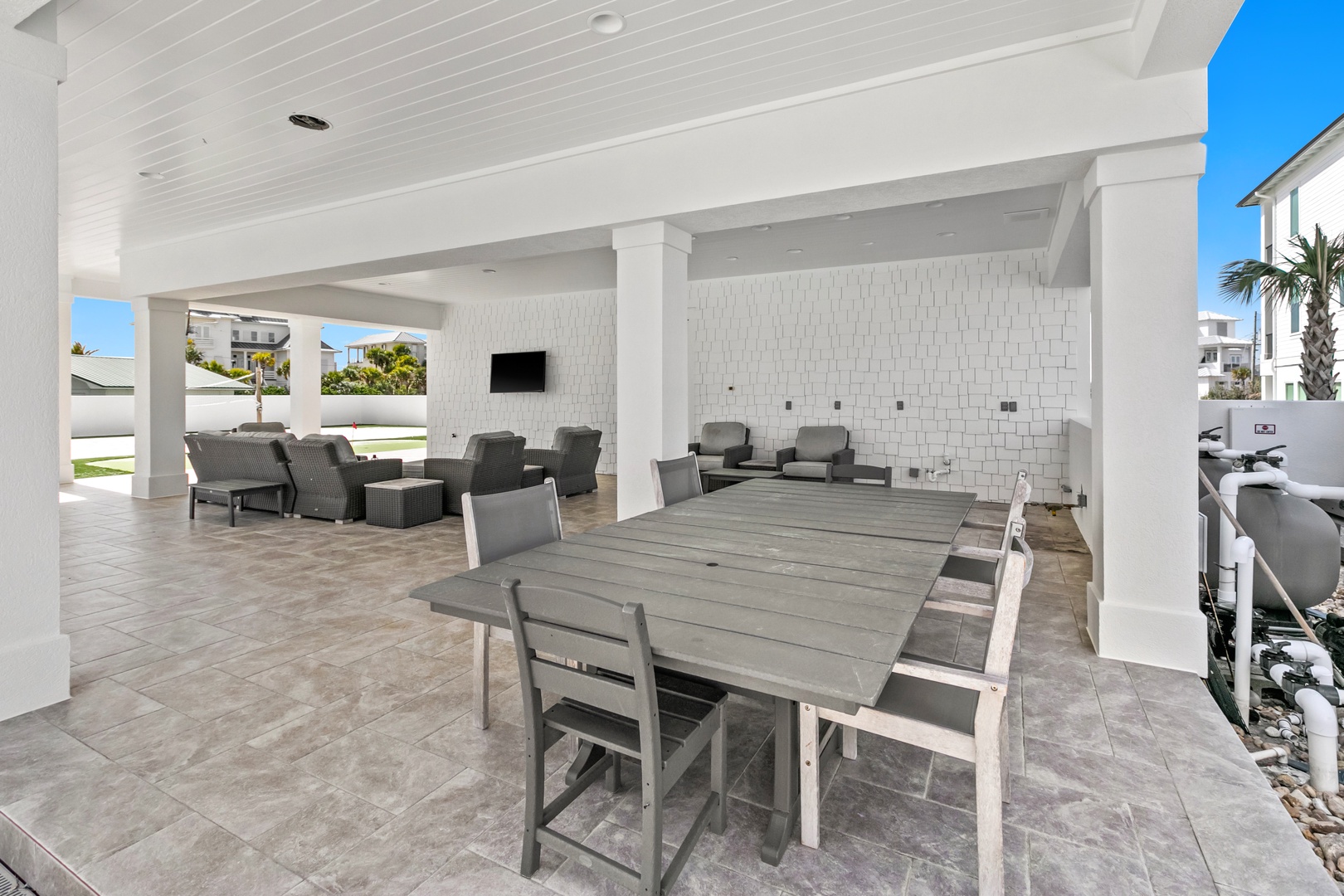 Gather around this spacious covered patio where your group can lounge comfortably in plush seating or share meals at the expansive dining table, all while enjoying the coastal breeze.