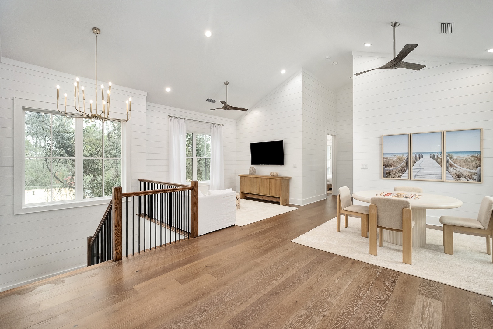 Relax in your bright, open living space featuring beautiful hardwood floors, elegant dining, and stunning ocean artwork that brings coastal tranquility indoors.