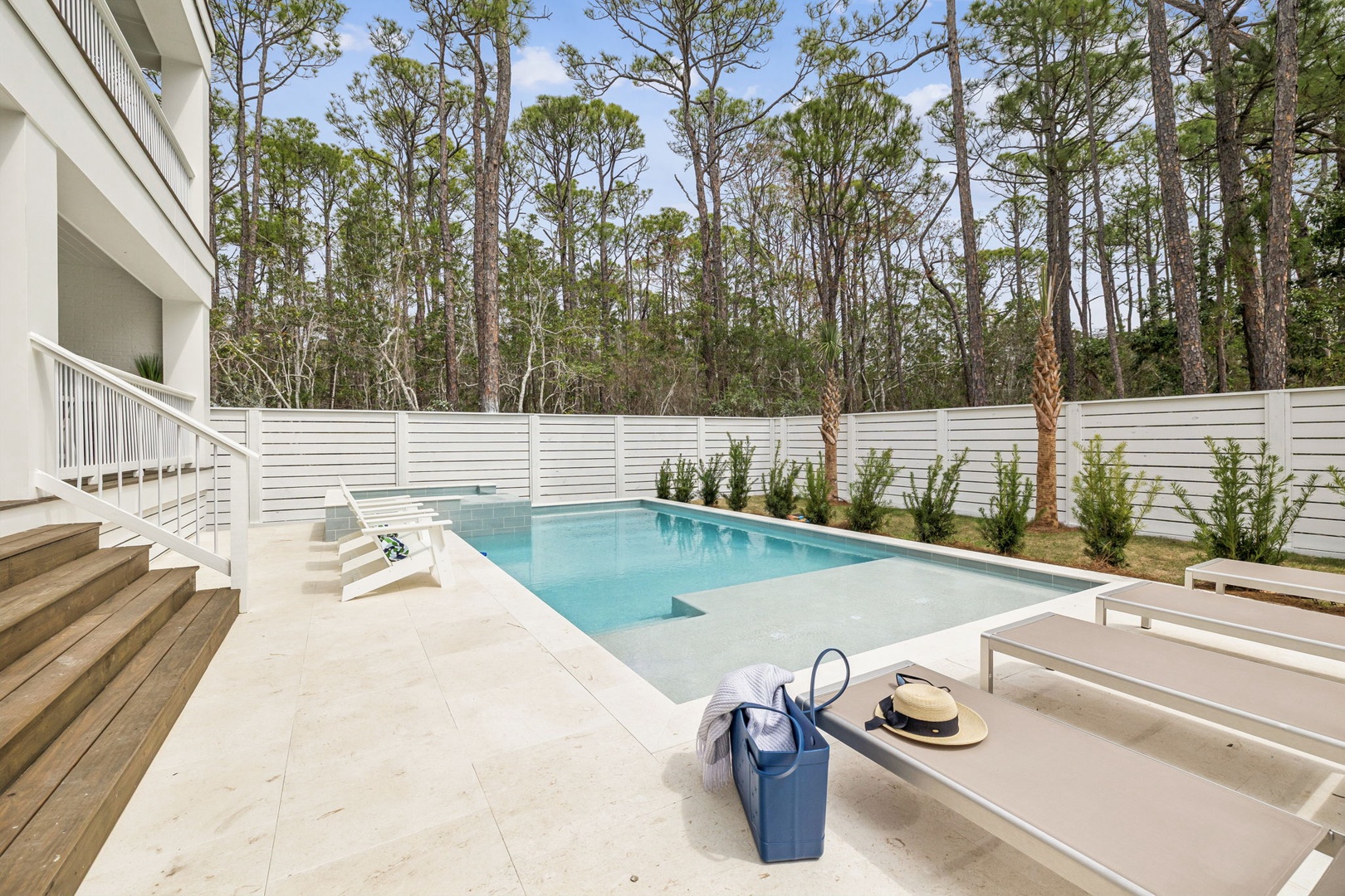Dive into your private oasis with this pristine pool surrounded by towering pines, creating the perfect backdrop for sunny afternoons.
