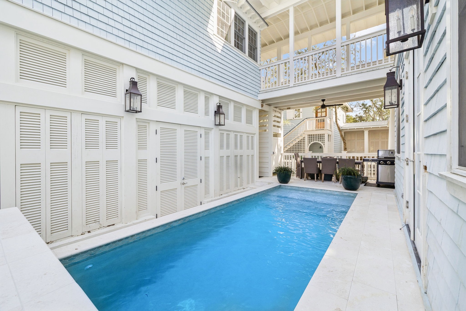 Your private oasis awaits in this stunning courtyard pool, where blue waters shimmer beneath white shutters and balconies.