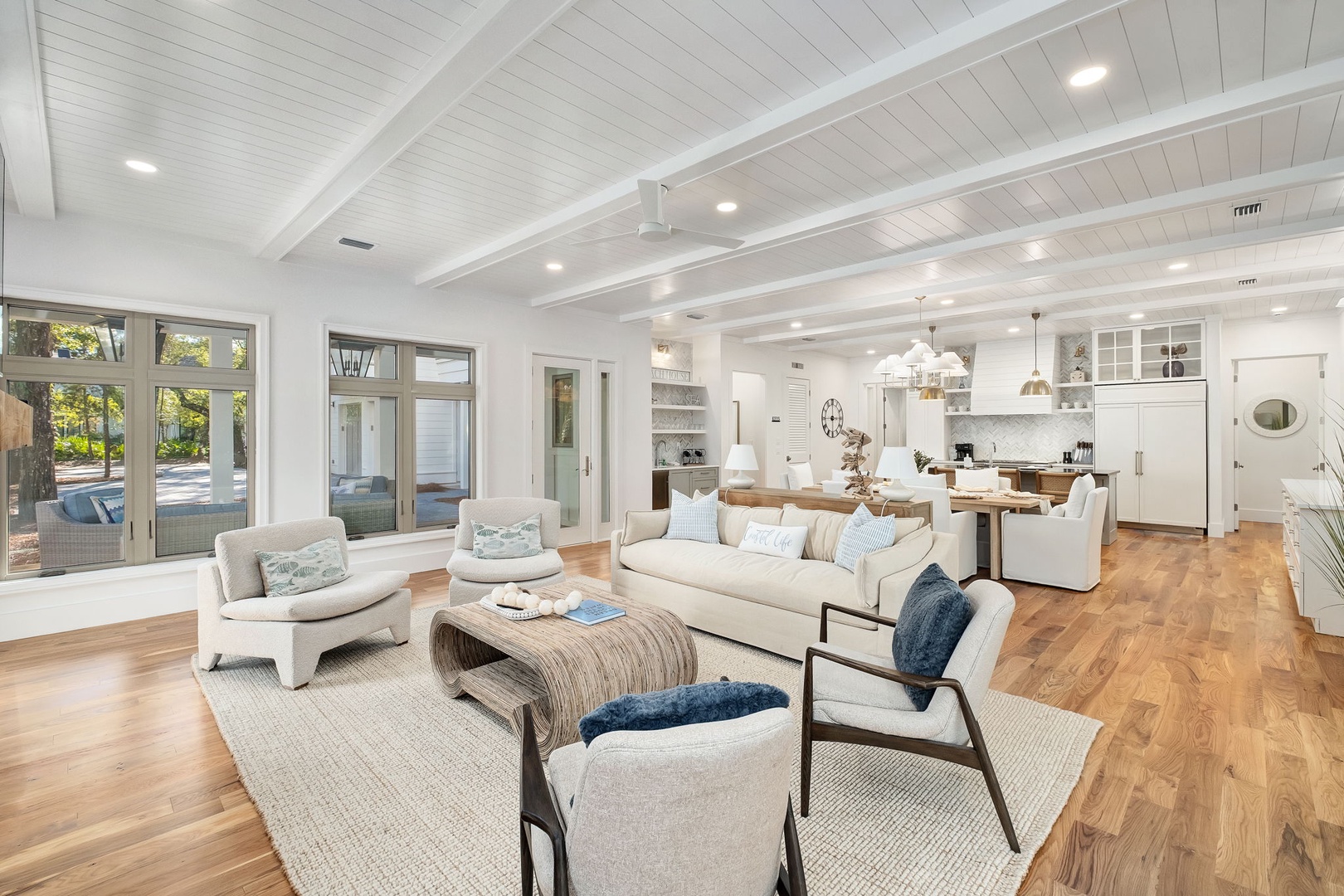 Relax in this stunning open-concept living space where coastal elegance meets comfort, featuring soaring beam ceilings and seamless indoor-outdoor flow.