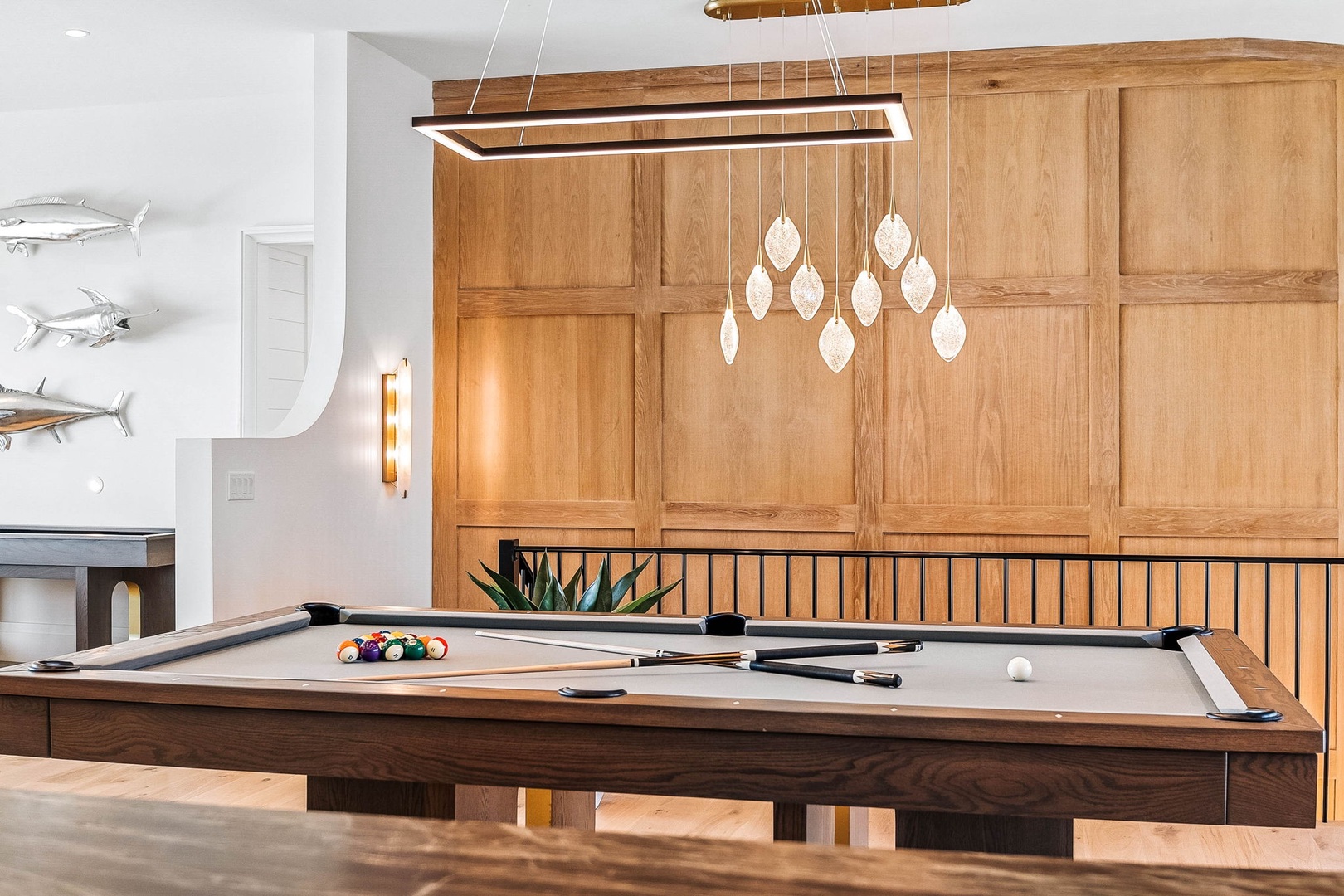 Challenge friends to a game at your private pool table beneath elegant lighting in this stylish entertainment space with warm wood accents.