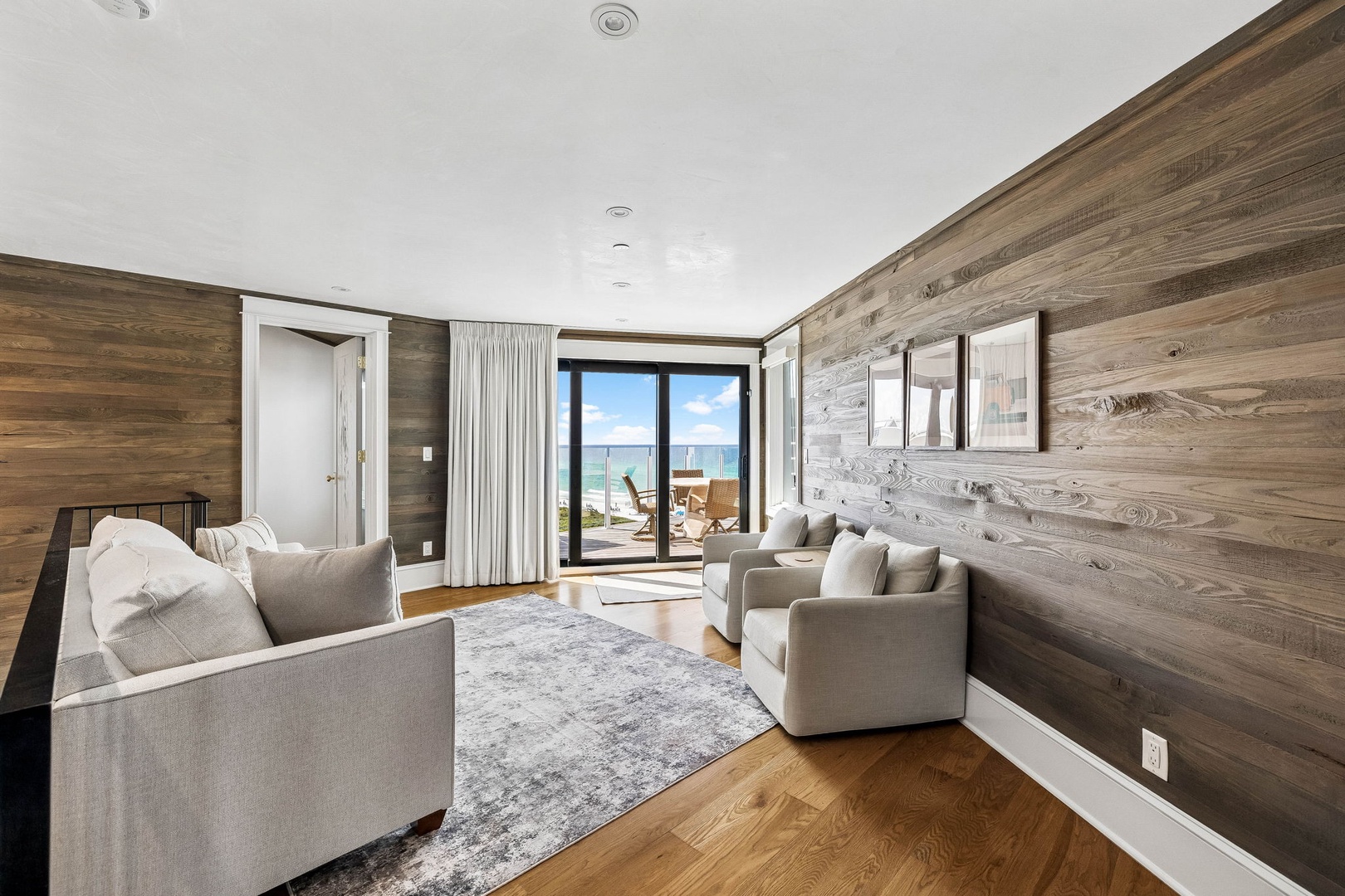 Sink into plush seating and soak up stunning ocean views through floor-to-ceiling doors. Warm wood walls and coastal breezes create your perfect seaside sanctuary.