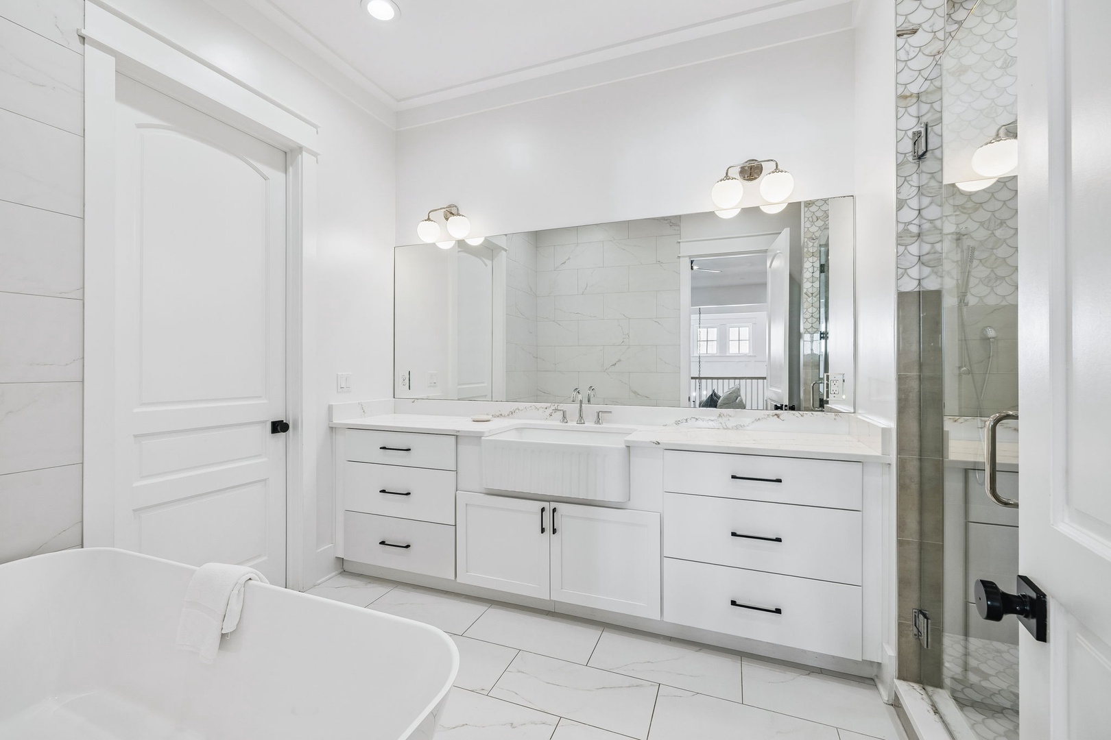 Step into your spa-like retreat with a gleaming white dual vanity, elegant fixtures, and a luxurious soaking tub—perfect for unwinding after a day of adventure.