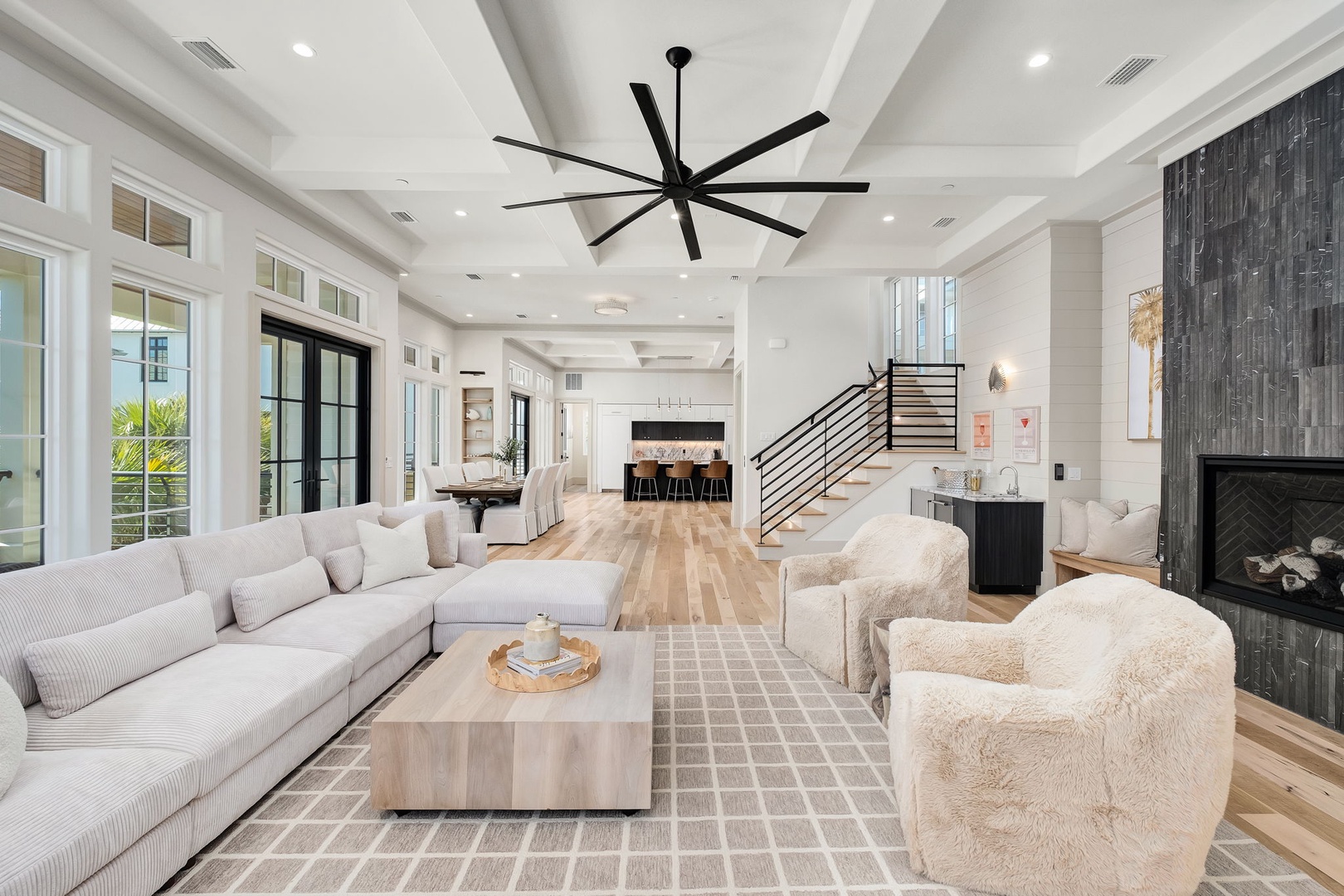 Step into your stunning open-concept living space with soaring coffered ceilings and elegant fireplace, perfect for gathering.
