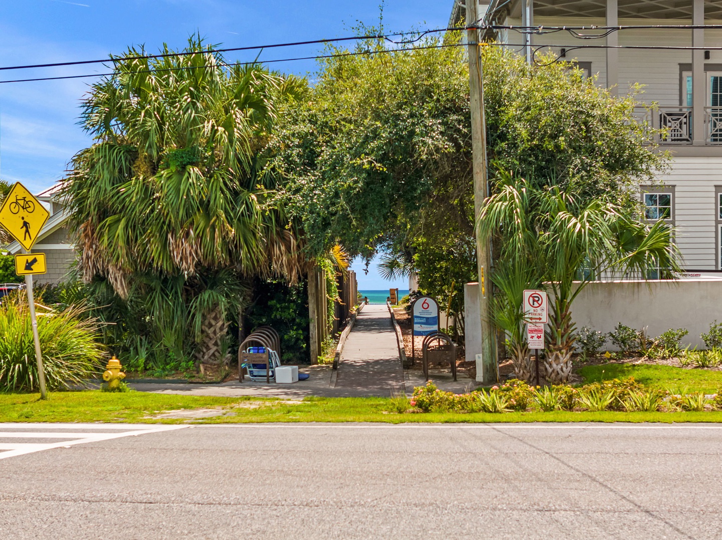 The beach access path is just steps away, framed by swaying palms and tropical greenery—an inviting gateway to sun, sand, and ocean breezes.