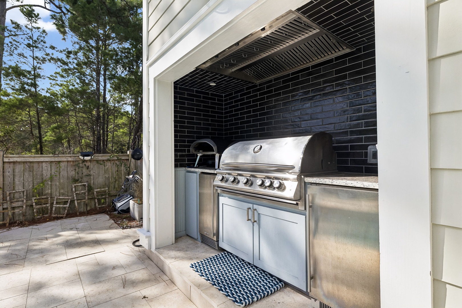 Enjoy effortless outdoor entertaining at your private covered grilling station, complete with premium stainless steel appliances and fridge. Your peaceful wooded backyard awaits just beyond the patio.