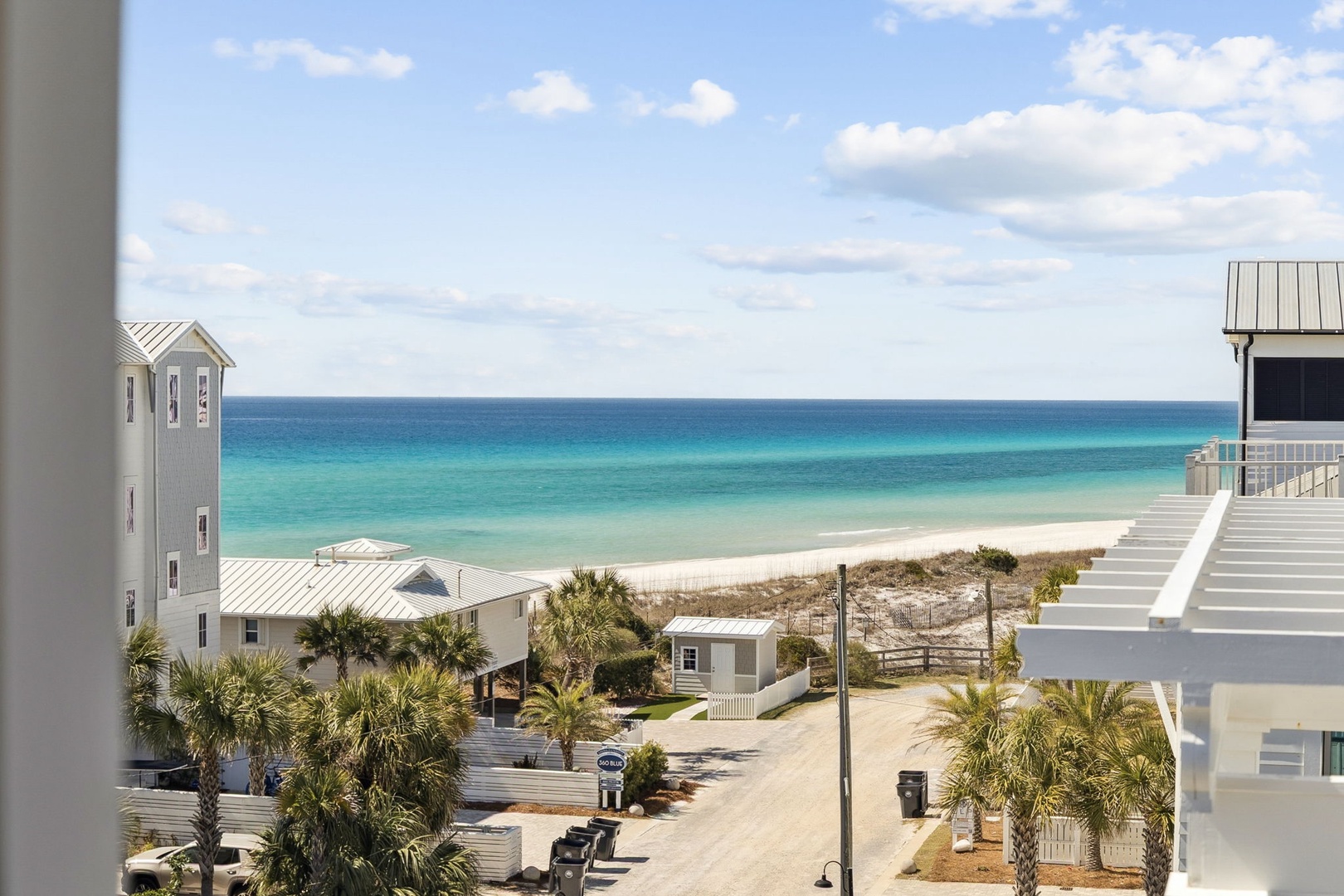 Stunning beachfront community features pristine white sand shores and turquoise waters, with coastal architecture and palm-lined streets creating an idyllic seaside setting.