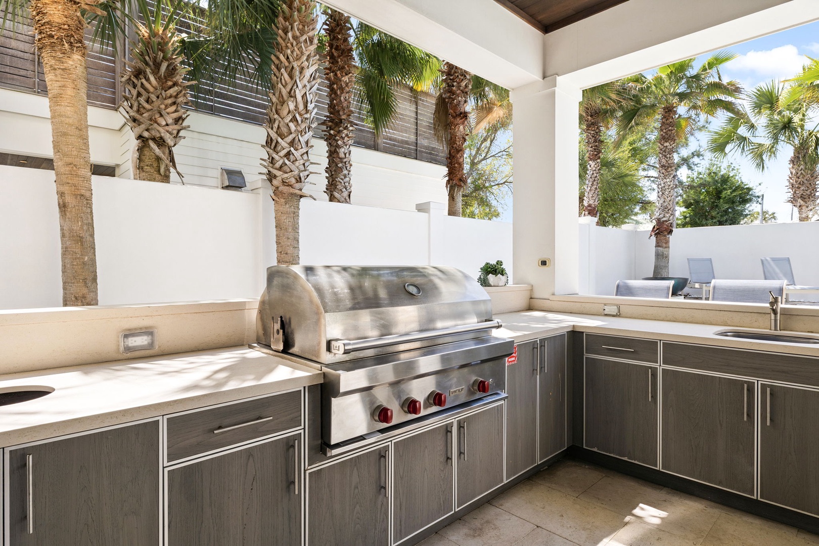 Your private outdoor kitchen features premium stainless steel appliances perfect for grilling while enjoying tropical palm views.