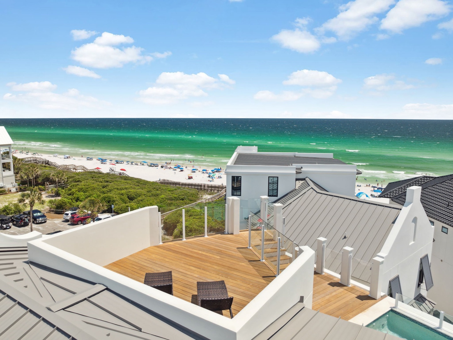 Elevated rooftop deck with stunning emerald Gulf waters and white sand beach views, featuring a sun-soaked lounging area perfect for soaking in coastal beauty.