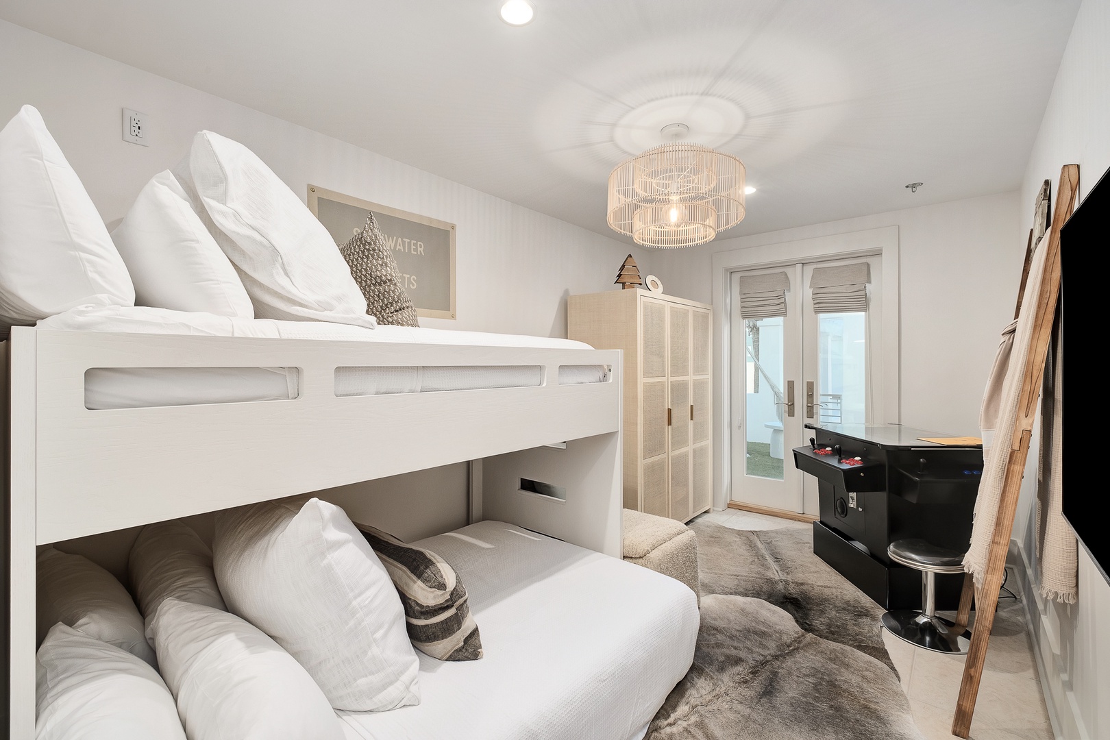 Your kids will love this modern bunk bed setup with crisp white linens and stylish lighting creating the perfect cozy retreat.