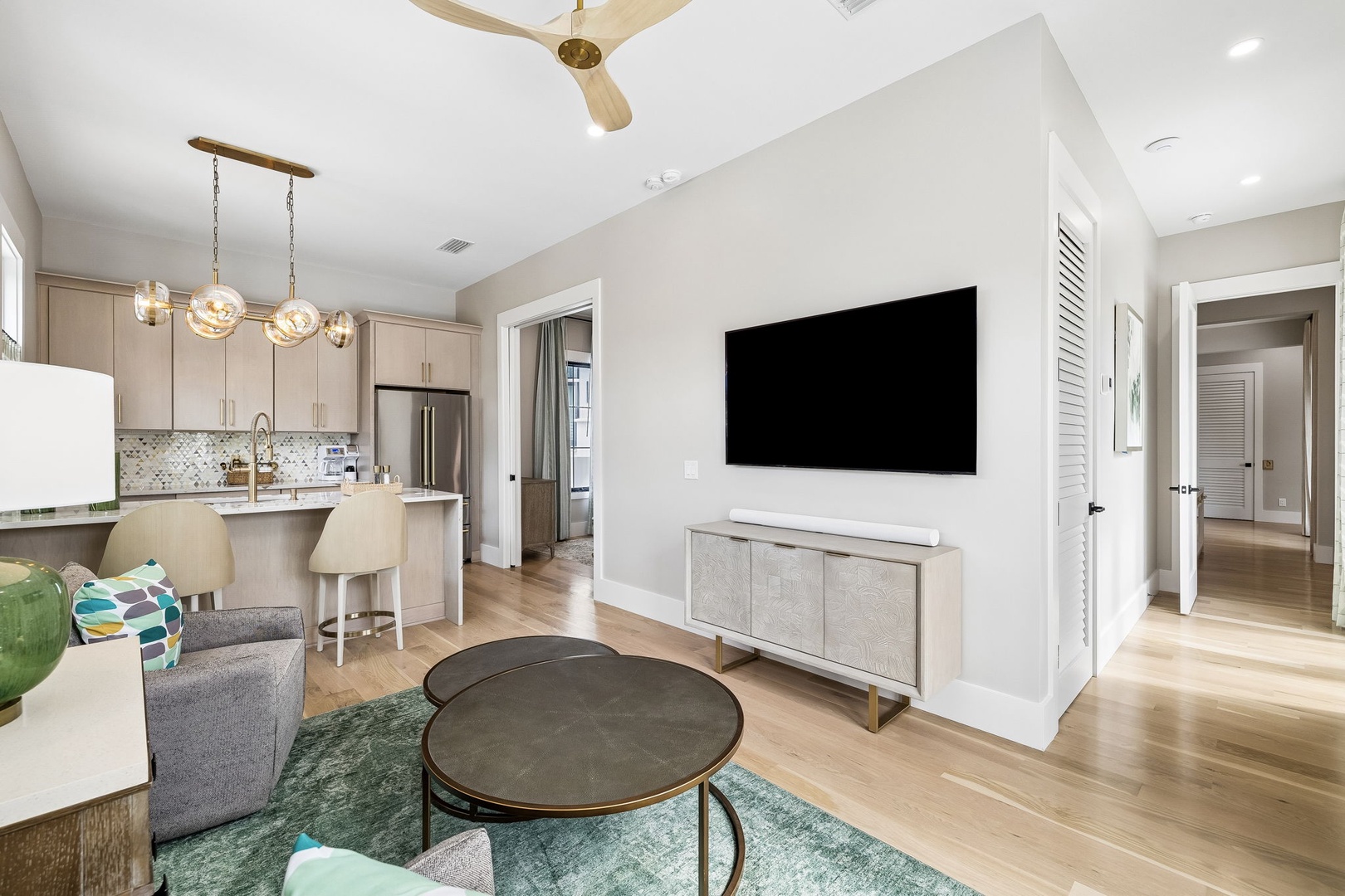 Your open-concept living space flows seamlessly from lounge to kitchen, with vaulted ceilings, warm wood floors, and modern coastal touches—perfect for relaxing or entertaining.