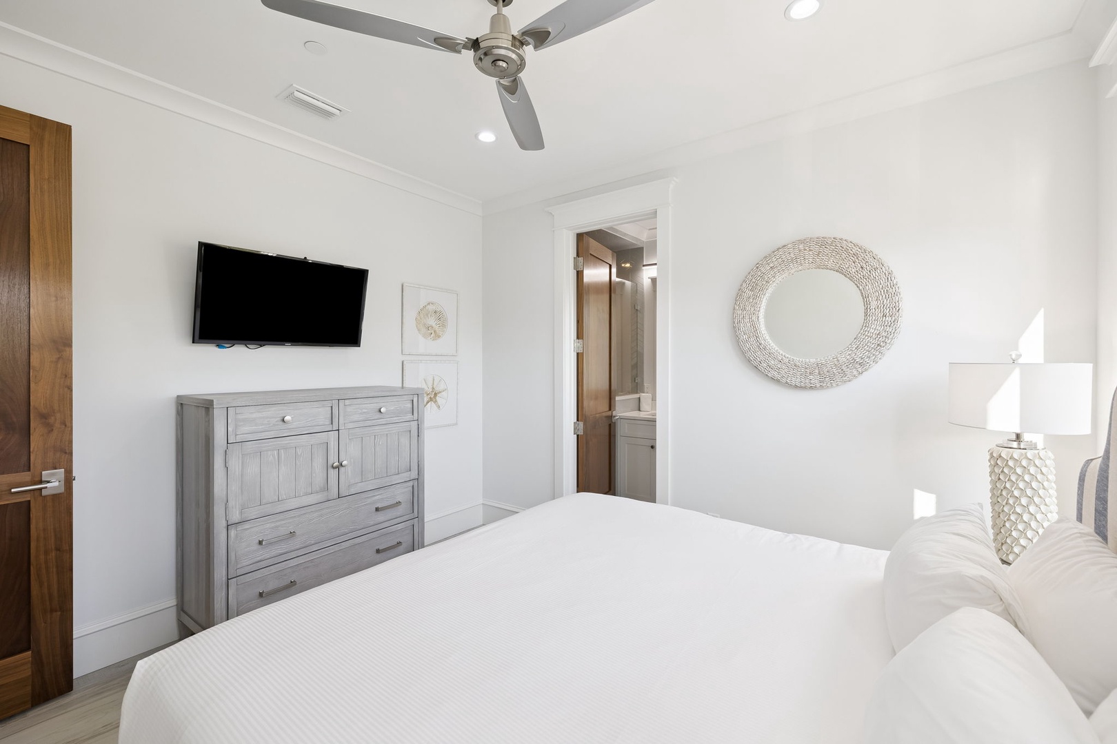 Drift off peacefully in your serene bedroom with crisp linens, ceiling fan, and coastal charm throughout.