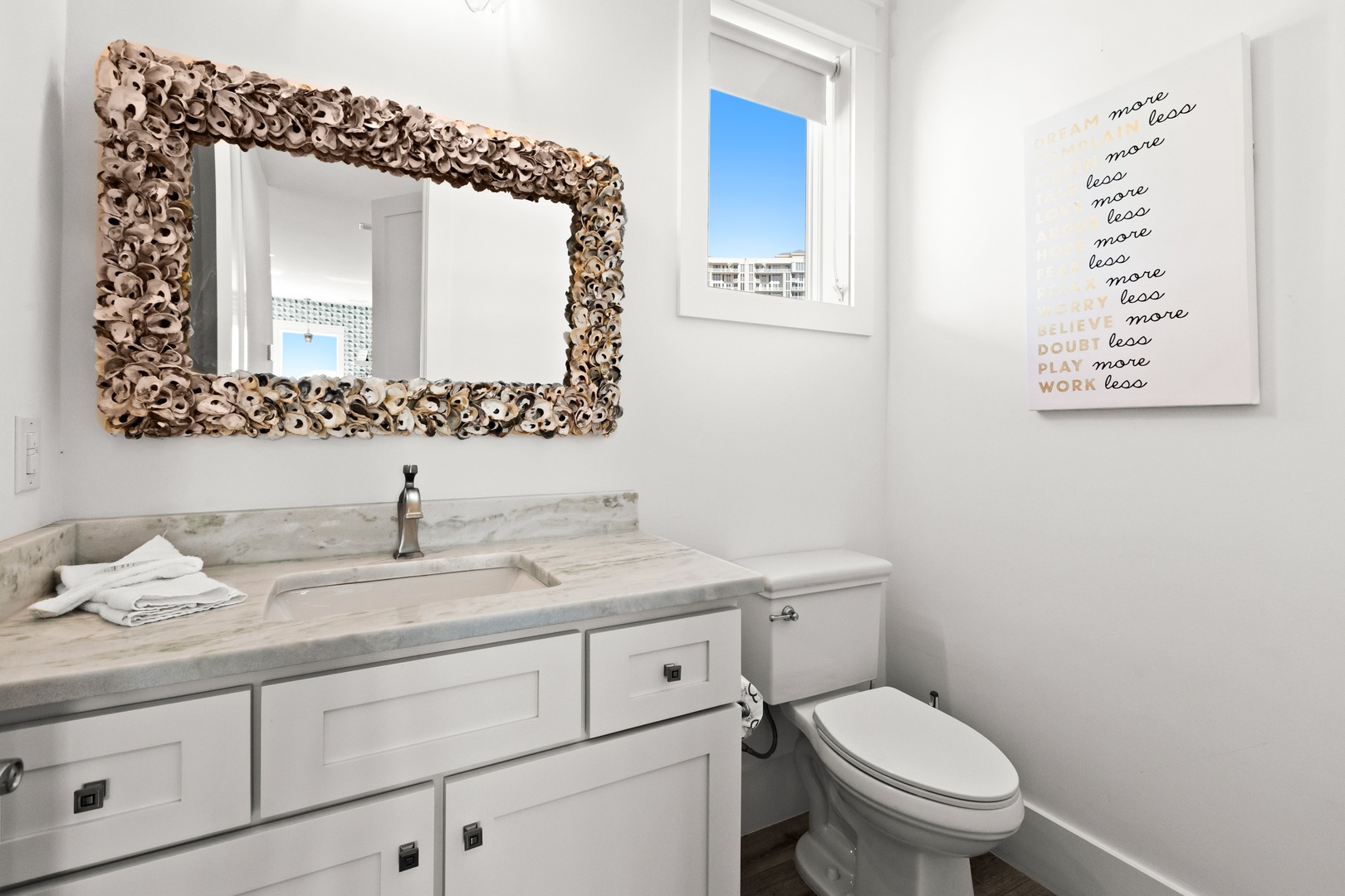 Freshen up in your stylishly appointed bathroom with a unique textured mirror, marble countertop, and soft towels waiting for you.