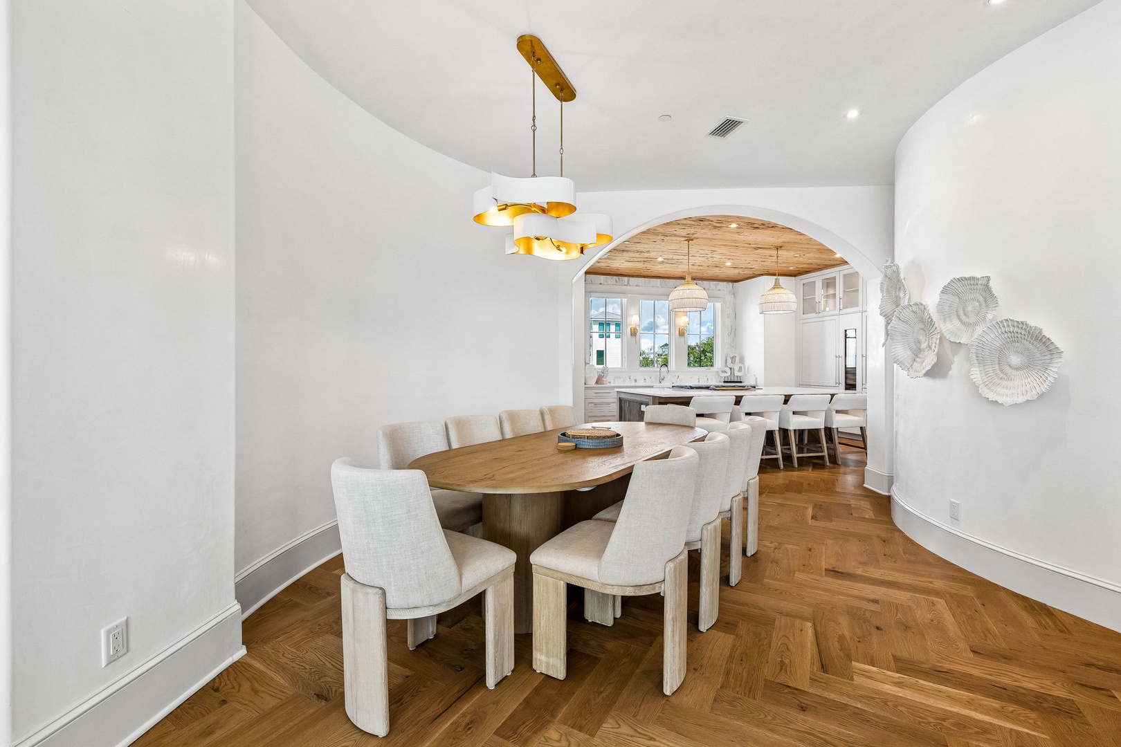 Picture yourself gathering around this stunning oval table, where natural wood tones and crisp white walls create a bright, airy space perfect for memorable meals with loved ones.