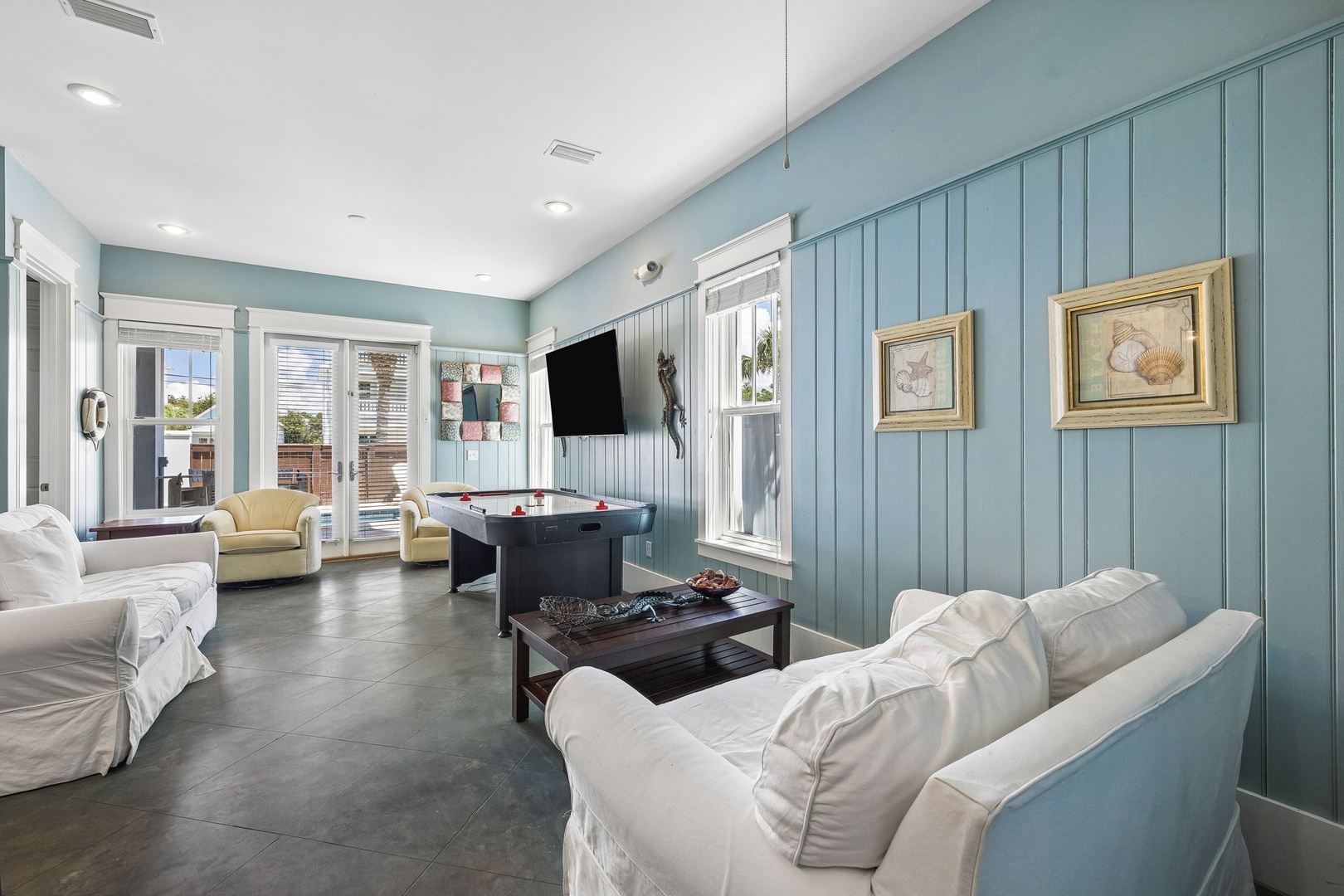 Gather with friends and family in this inviting game room, where soothing coastal blue tones and plenty of natural light create the perfect backdrop for your vacation fun.