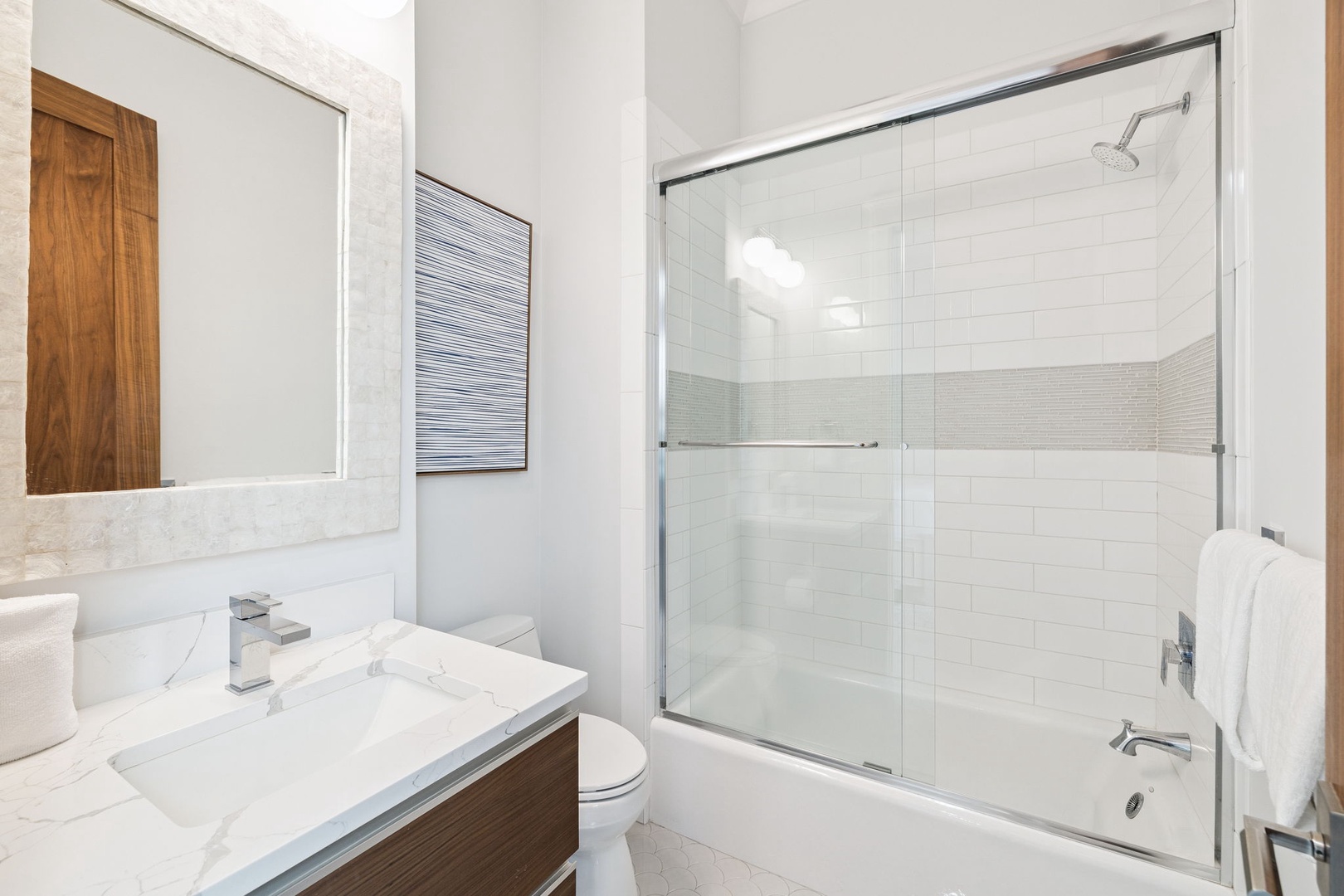 Unwind in your pristine bathroom with marble countertops, rainfall shower, and plush towels awaiting your arrival.