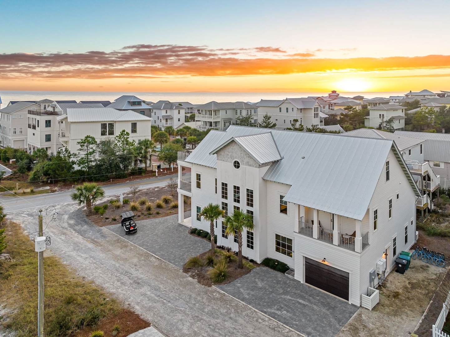 Stunning coastal property nestled in charming beachside community, featuring modern architecture and peaceful residential setting at golden hour.