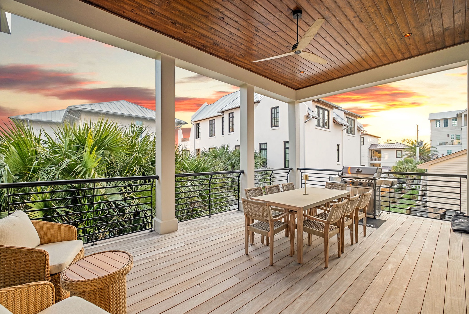 Your private covered terrace overlooks a tropical neighborhood as dramatic sunset colors paint the evening sky.