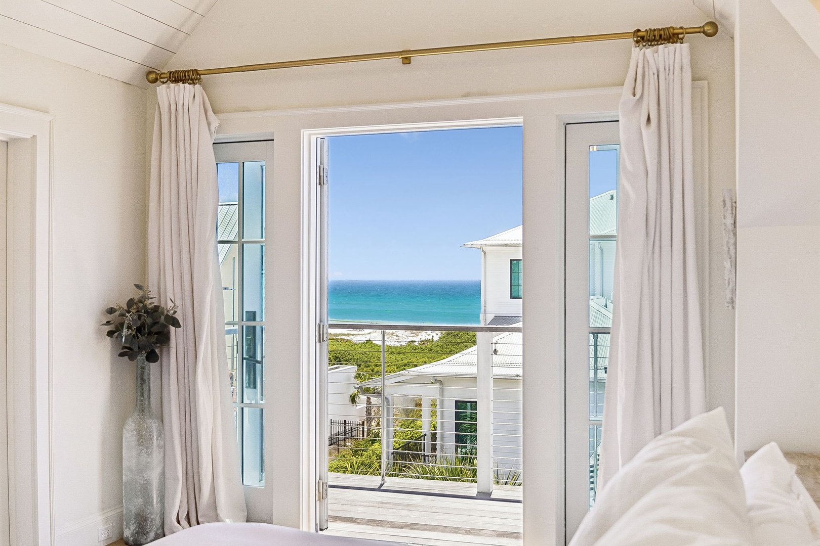 Wake up to stunning turquoise waters from your private balcony. Soft white linens, airy coastal design, and direct ocean views create your serene beachside escape.