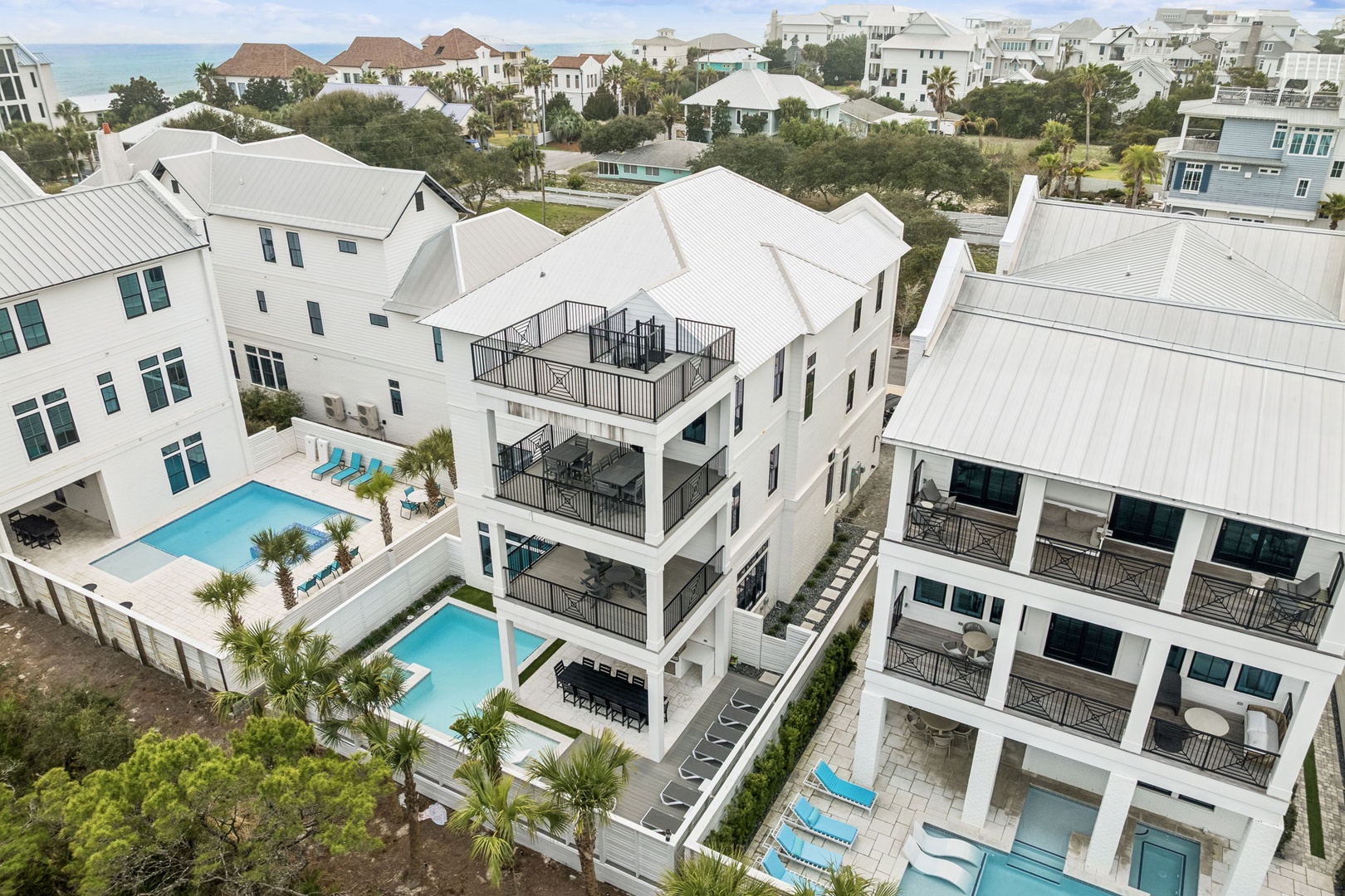 Luxury coastal homes with private pools nestled in an exclusive beachside community near pristine turquoise waters.