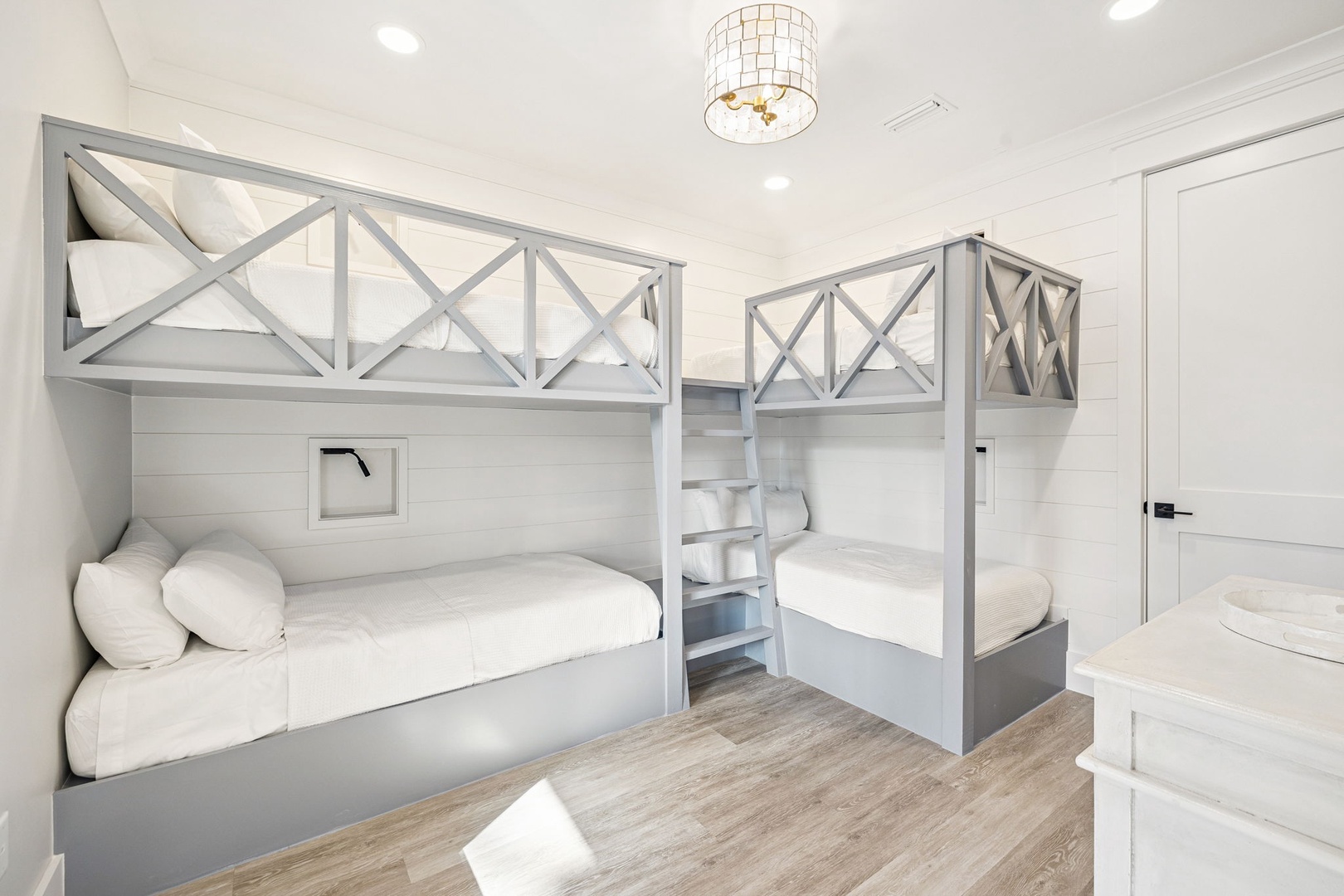 Your kids will love these stylish bunk beds with cozy reading nooks and elegant pendant lighting.