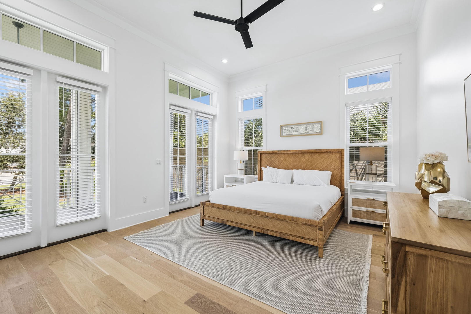 Your bright and airy primary suite features soaring ceilings, warm wood tones, and French doors that open to the outdoors, creating a serene sanctuary for restful nights.