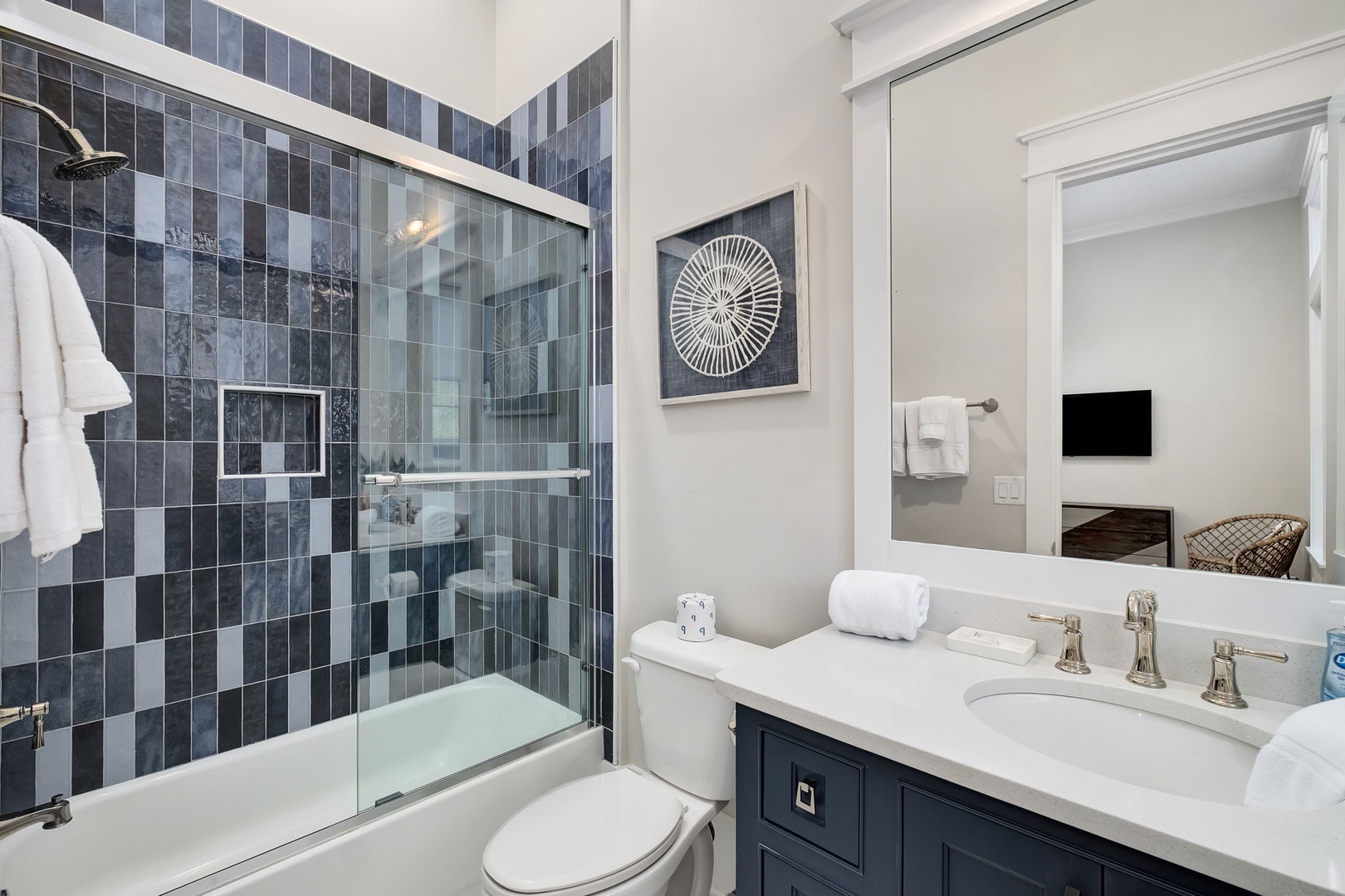 Refresh in your elegant bathroom with stunning mosaic tile shower, plush towels, and modern fixtures.