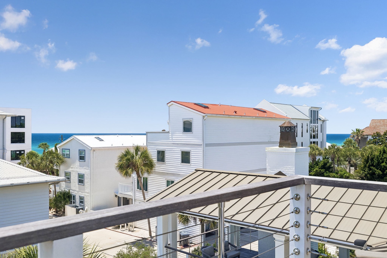 Coastal neighborhood surrounds the property, with nearby beach access and ocean glimpses visible from the residential area. Palm trees and modern architecture characterize the surrounding community.