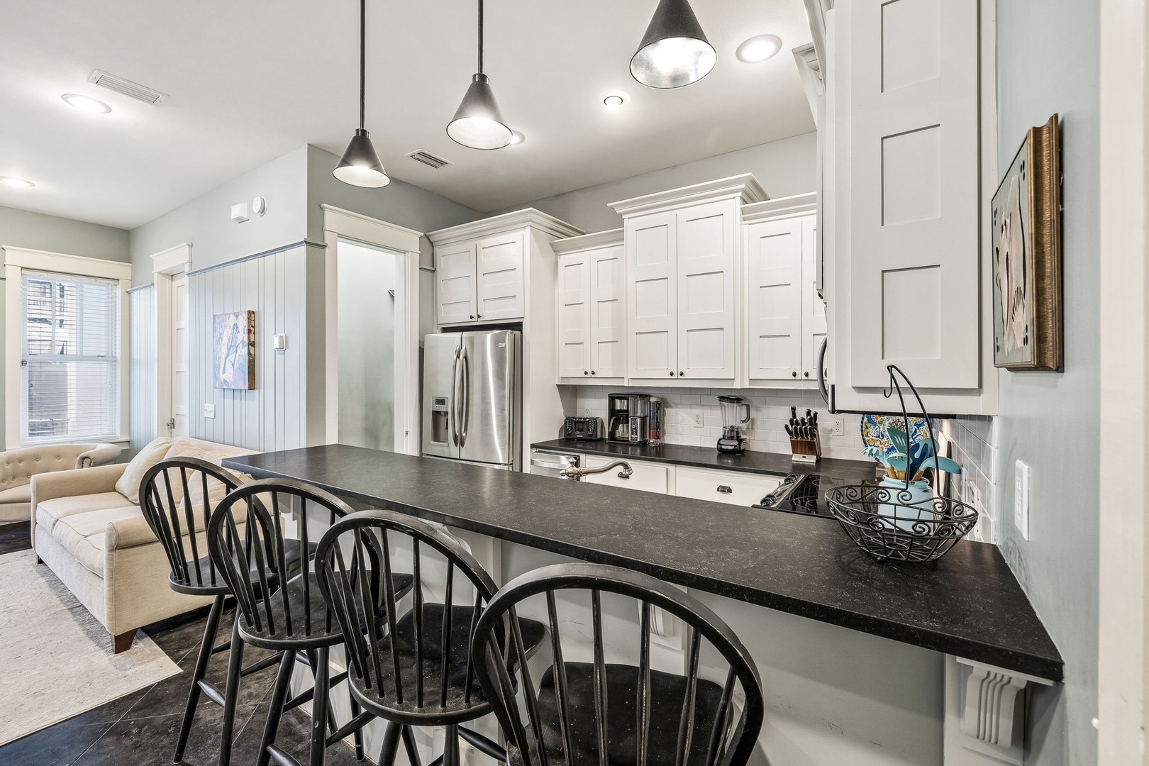 Gather around the sleek breakfast bar in this bright, welcoming kitchen, where modern appliances and thoughtful design make cooking feel effortless. Enjoy morning coffee or casual meals in this elegant, open space.