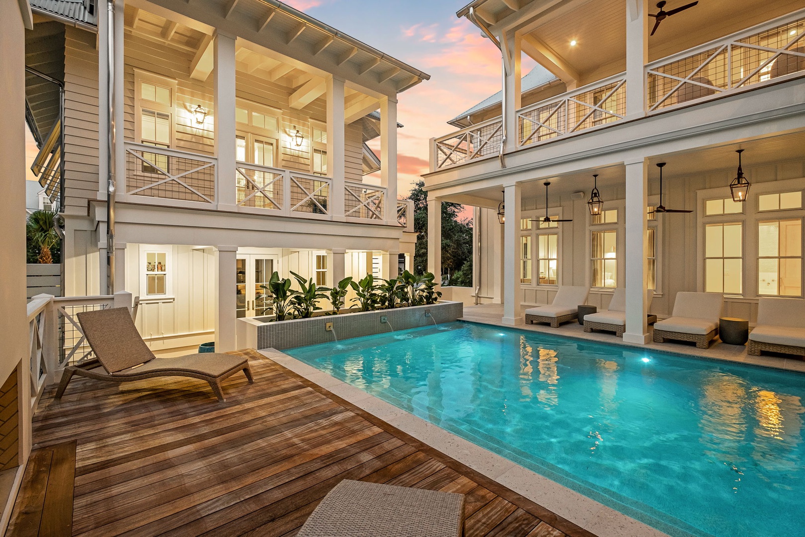 A stunning luxury home with private pool at twilight, showcasing elegant architecture and waterfront deck perfect for tropical relaxation.